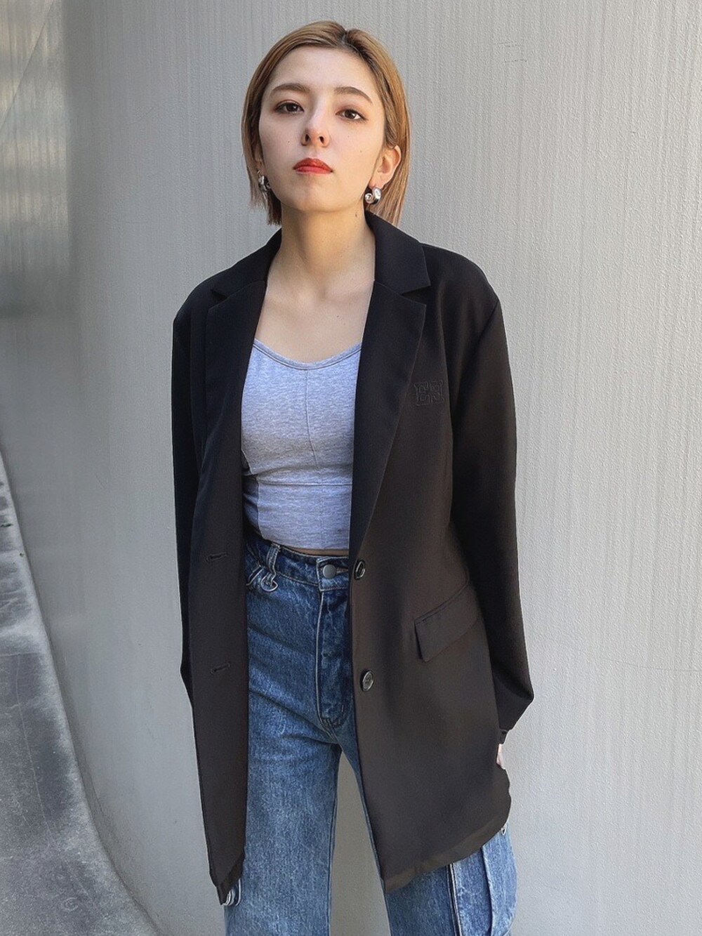 ブラック系のテーラードジャケット、ブルー系のデニムパンツ、ブラック系のローファーを着用したレディースの春コーディネートの4枚目の写真