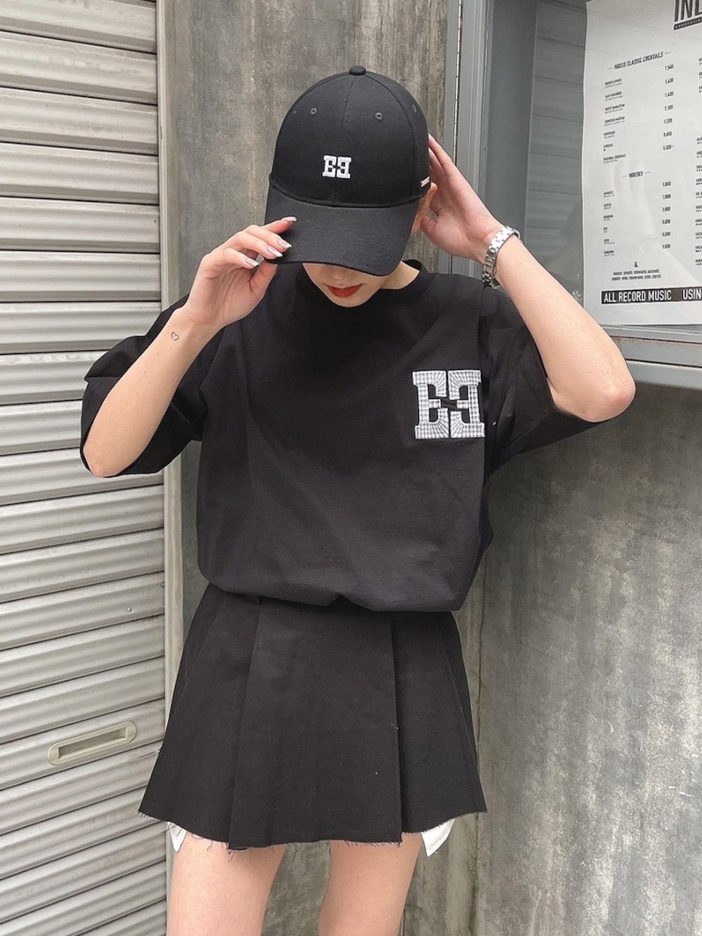 ブラック系のスカート、ブラック系のTシャツ/カットソー、ブラック系のブーツを着用したレディースの春コーディネートの2枚目の写真