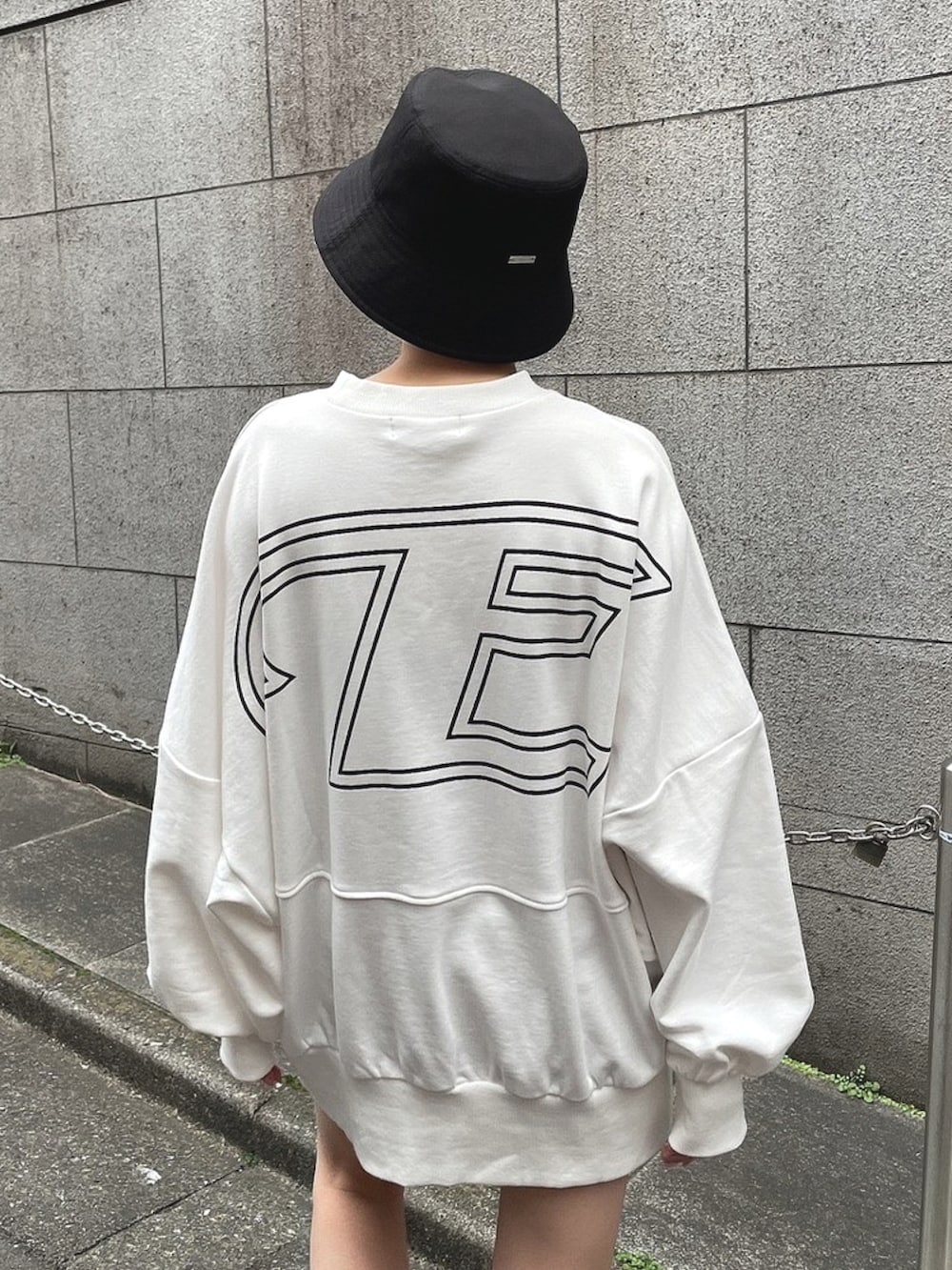 ホワイト系のTシャツ/カットソー、ブラック系のブーツ、ブラック系のハットを着用したレディースの春コーディネートの5枚目の写真