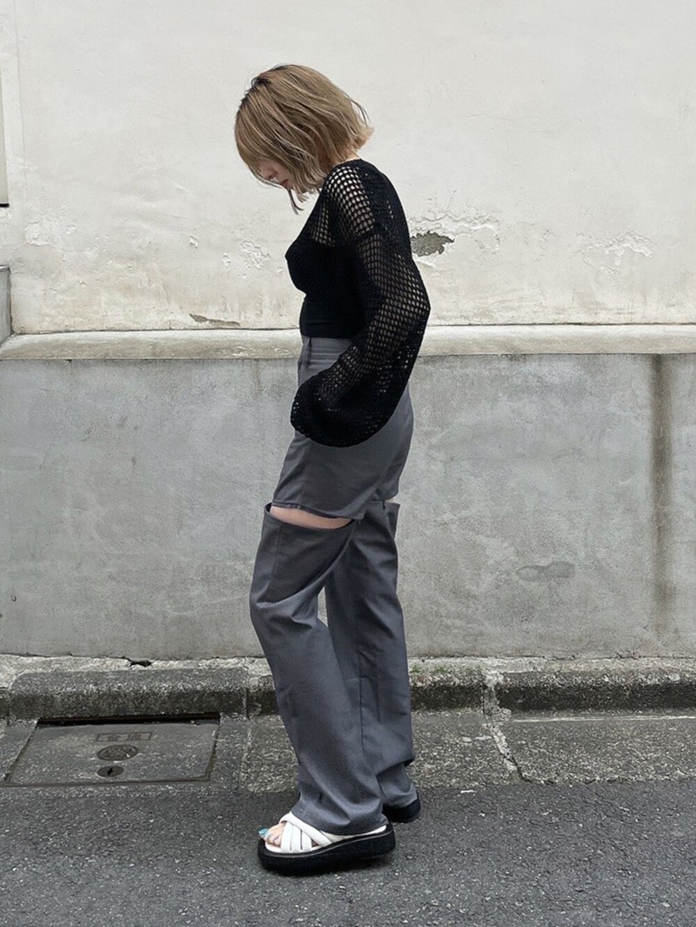 ブラック系のニット/セーター、ブラック系のキャミソール、グレー系のスラックスを着用したレディースの夏コーディネートの2枚目の写真