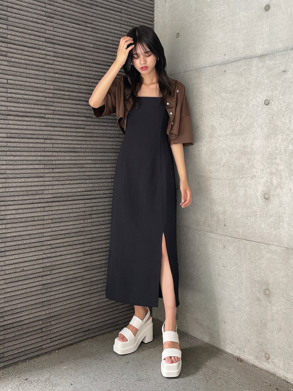 ブラック系のワンピース、ホワイト系のサンダル、ブラウン系のTシャツ/カットソーを着用したレディースの夏コーディネートの3枚目の写真