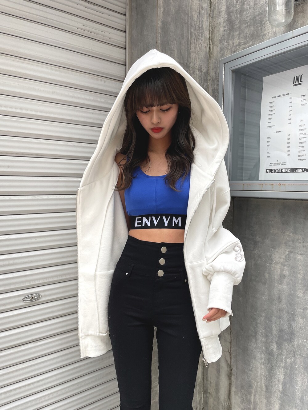 ホワイト系のパーカー、ブルー系のタンクトップ、ブラック系のその他パンツを着用したレディースの春コーディネートの4枚目の写真