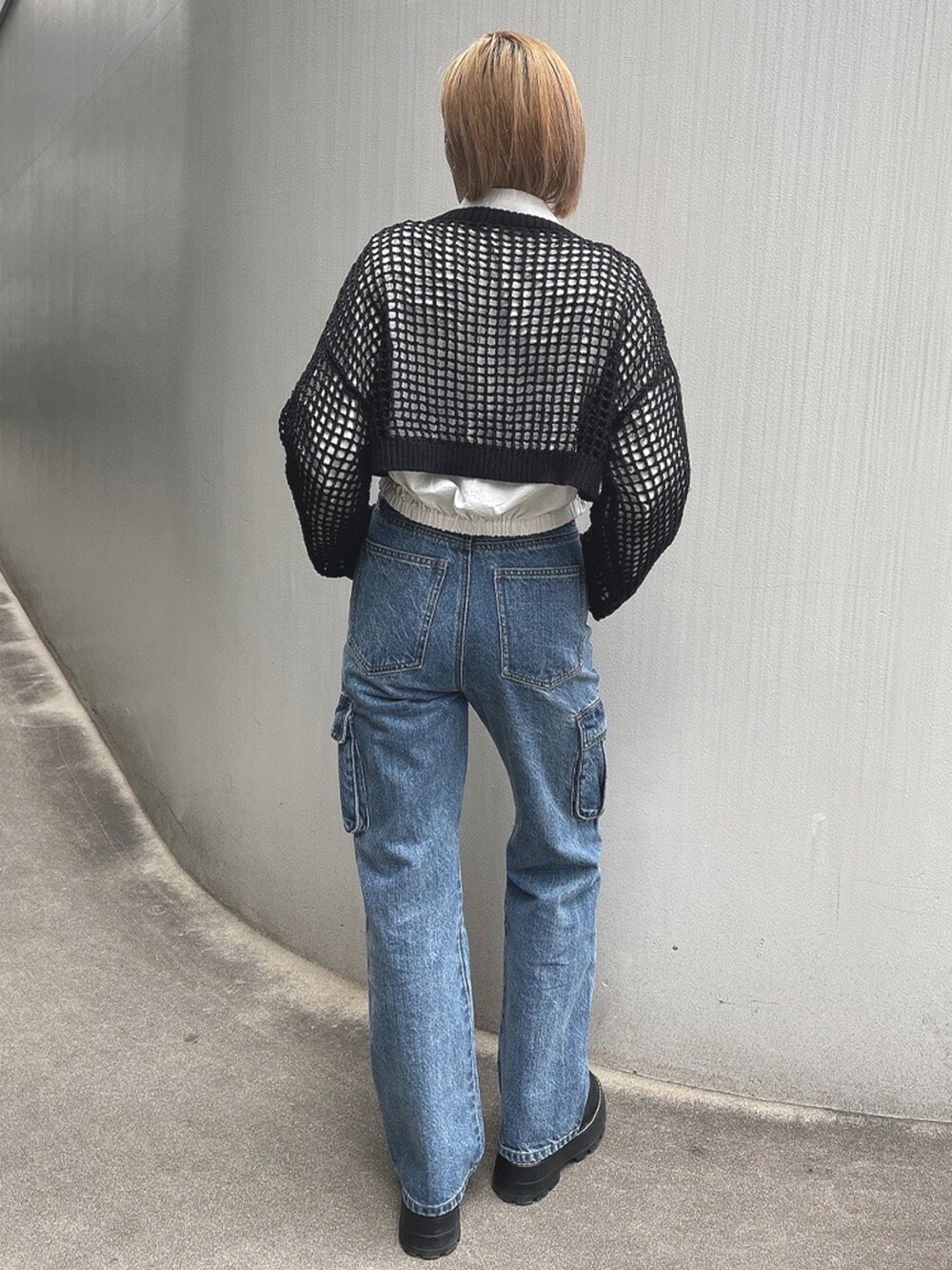 ホワイト系のシャツ/ブラウス、ブラック系のニット/セーター、ブルー系のデニムパンツを着用したレディースの春コーディネートの3枚目の写真