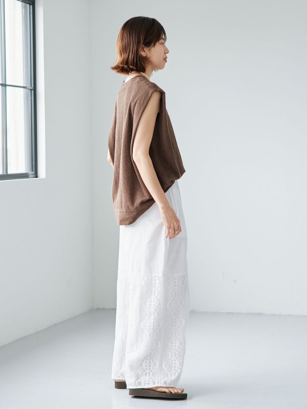ホワイト系のその他パンツ、グリーン系のTシャツ/カットソー、ブラウン系のサンダルを着用したレディースの夏コーディネートの2枚目の写真