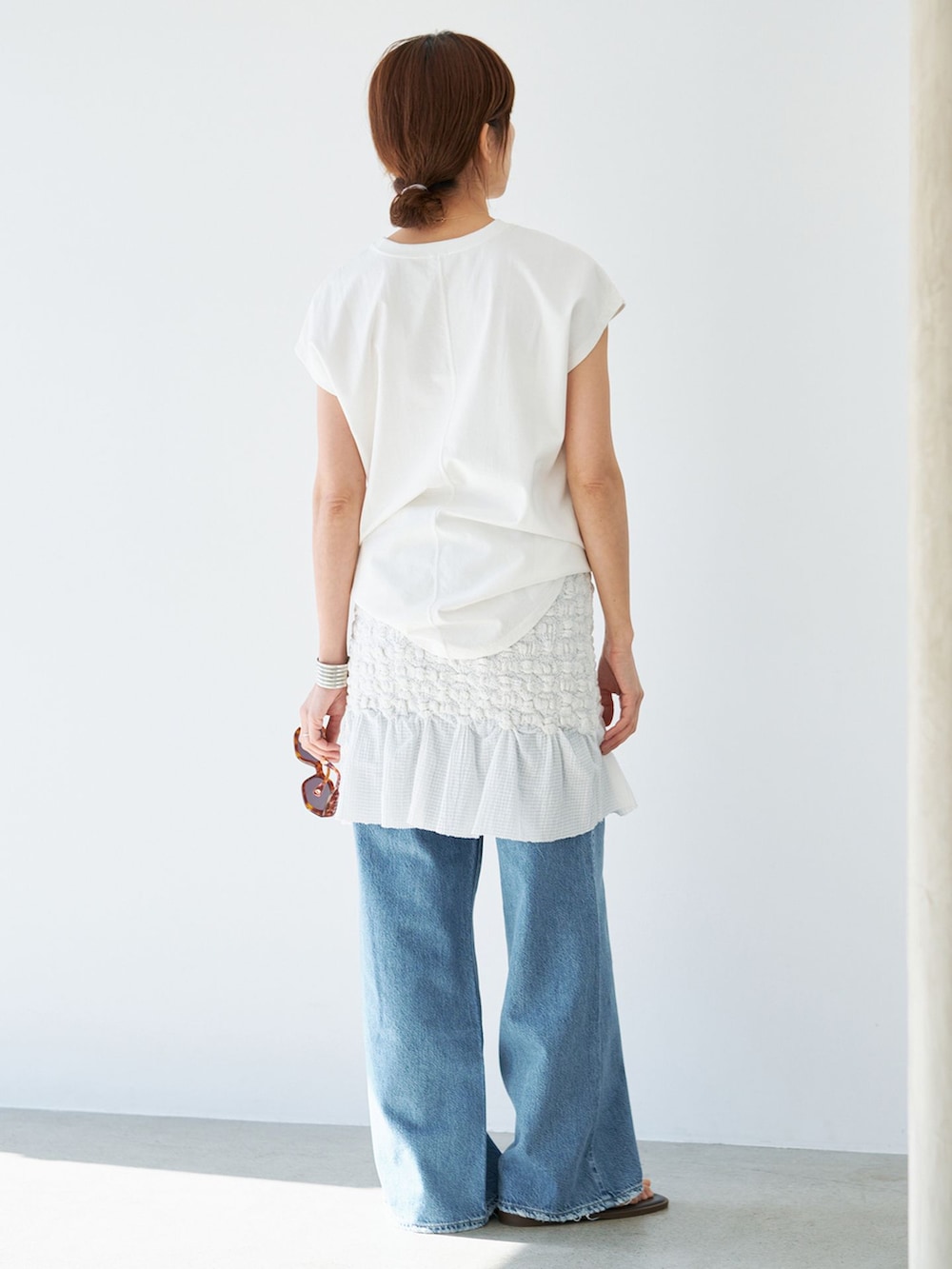 ホワイト系のスカート、ホワイト系のTシャツ/カットソー、ブラウン系のサンダルを着用したレディースの春コーディネートの4枚目の写真