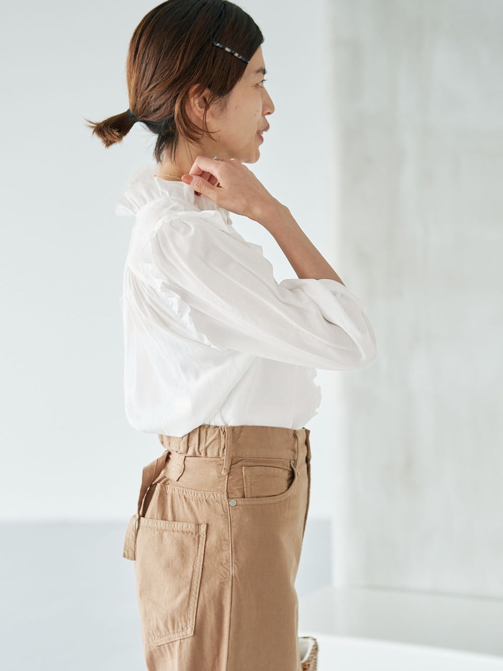 イエロー系のチノパンツ、ホワイト系のシャツ/ブラウス、イエロー系のハンドバッグを着用したレディースの夏コーディネートの5枚目の写真