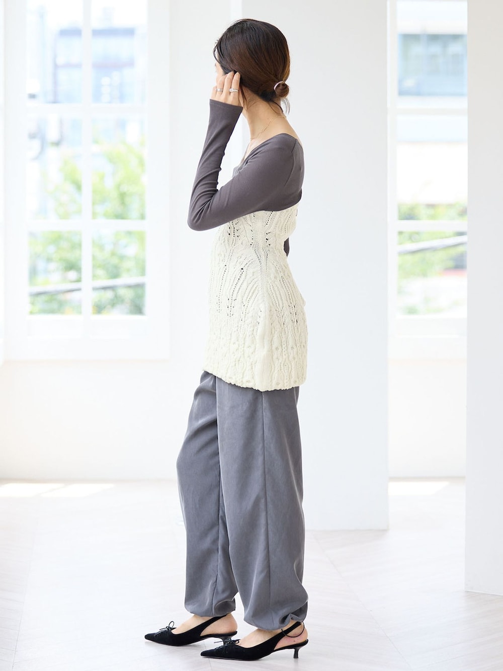 グレー系のその他パンツ、グレー系のTシャツ/カットソー、ホワイト系のニット/セーターを着用したレディースの秋コーディネートの2枚目の写真