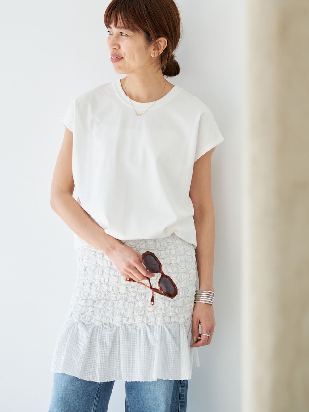 ホワイト系のスカート、ホワイト系のTシャツ/カットソー、ブラウン系のサンダルを着用したレディースの春コーディネートの10枚目の写真