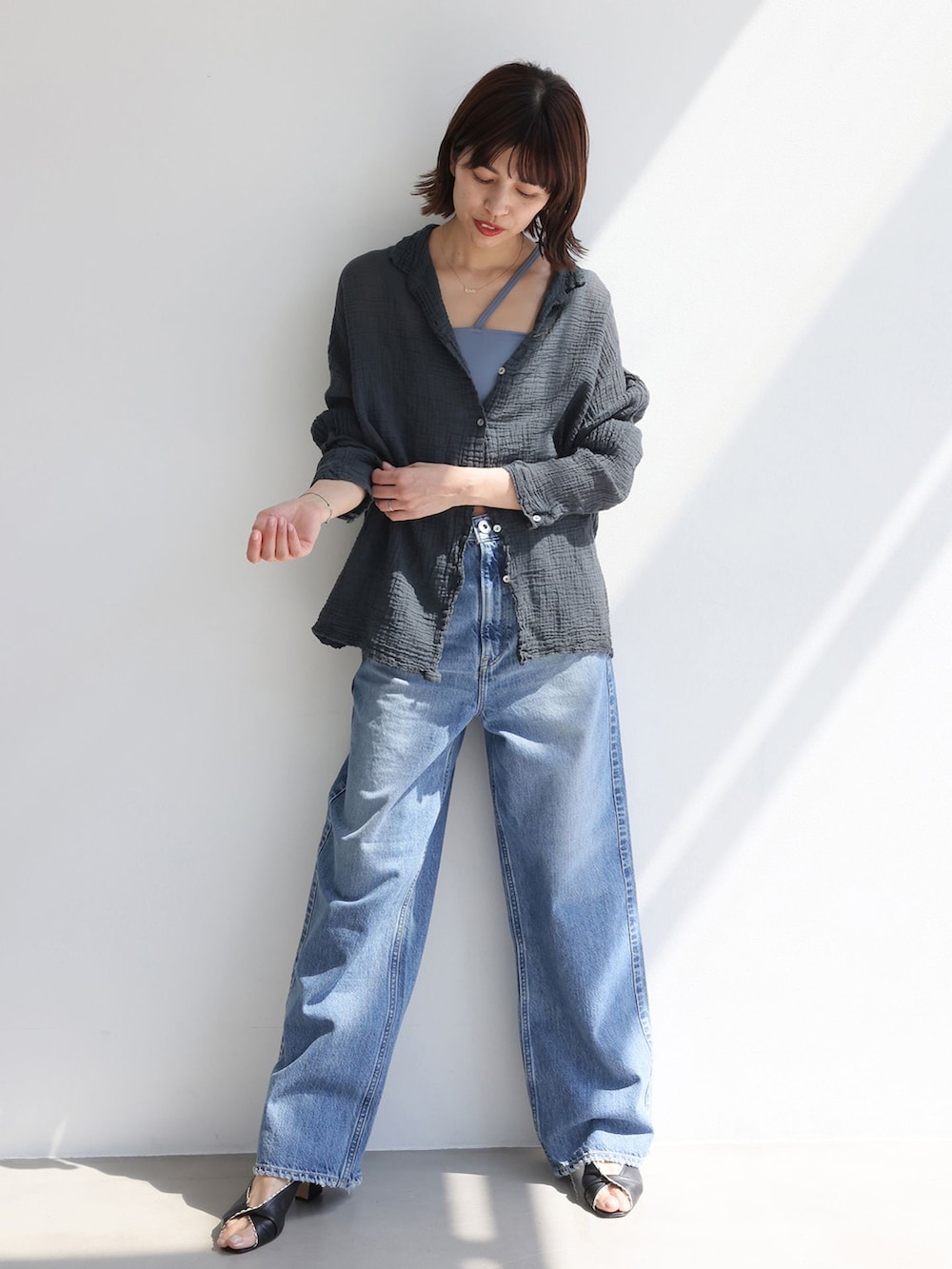 ブルー系のデニムパンツ、ブラック系のシャツ/ブラウスを着用したレディースの夏コーディネートの2枚目の写真
