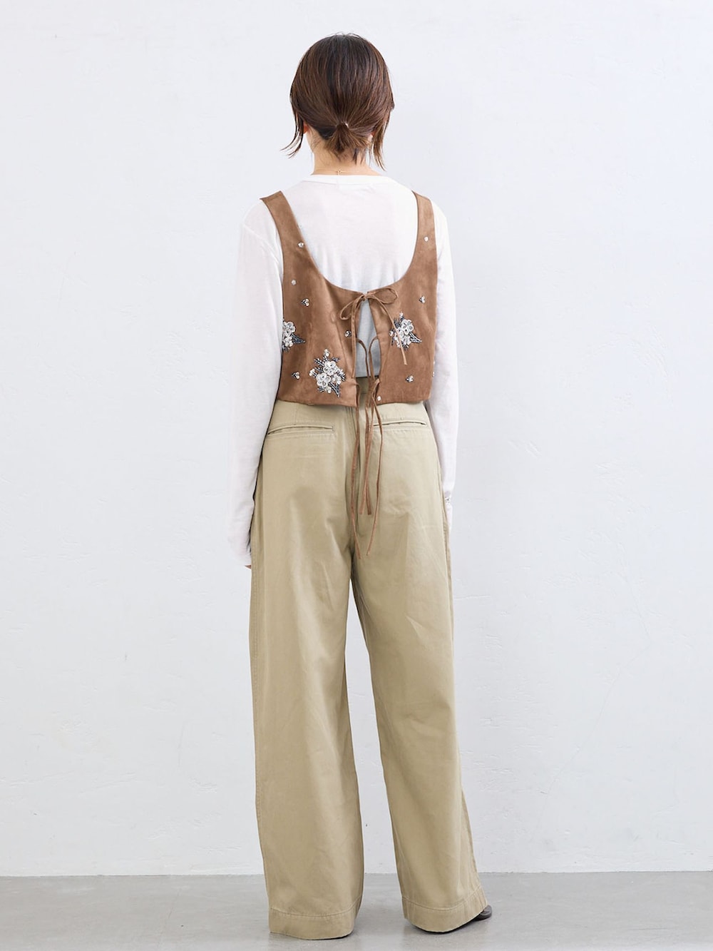 ベージュ系のチノパンツ、イエロー系のシャツ/ブラウス、ホワイト系のTシャツ/カットソーを着用したレディースの夏コーディネートの2枚目の写真