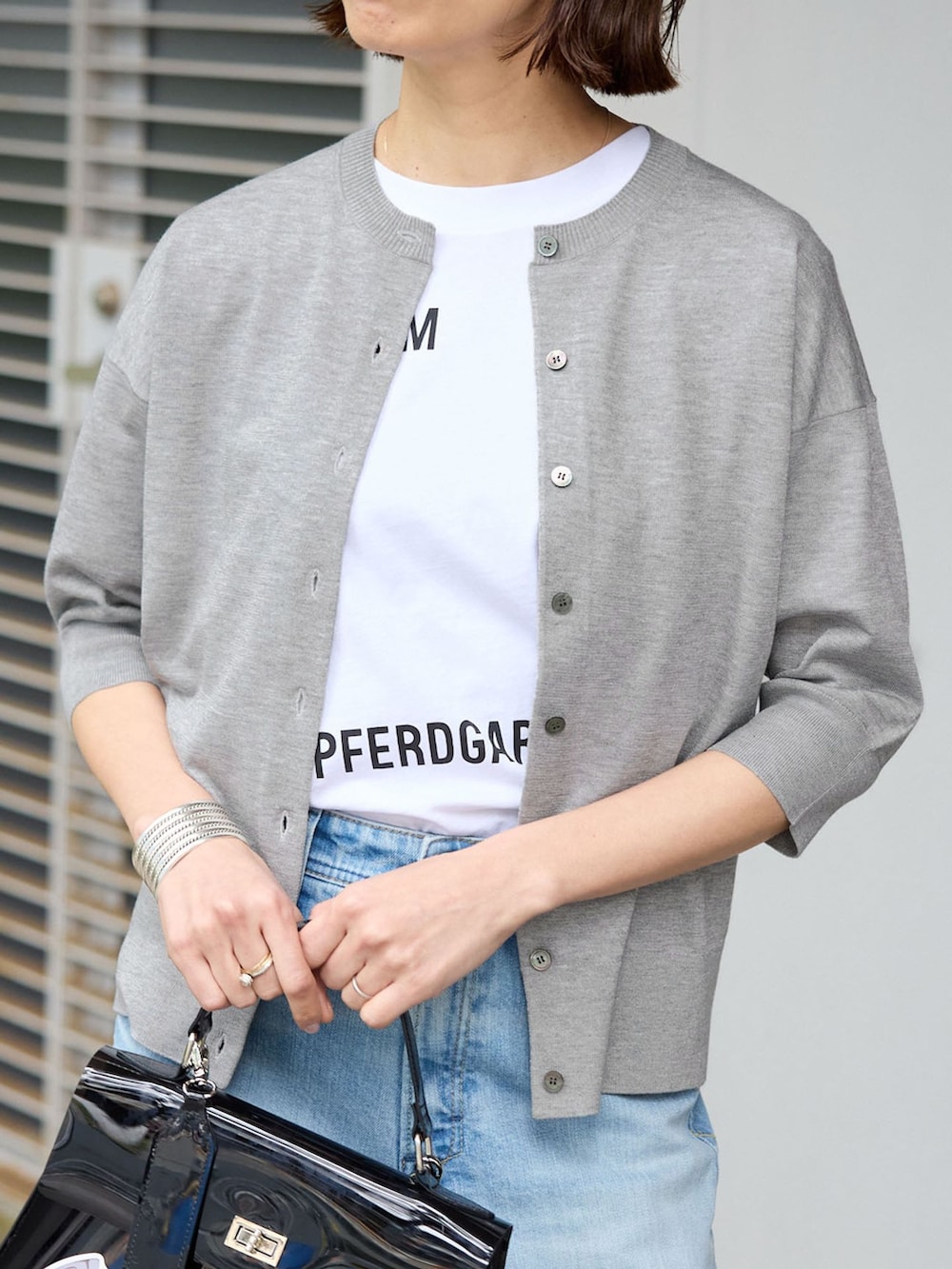 ブルー系のデニムパンツ、ホワイト系のTシャツ/カットソー、グレー系のカーディガン/ボレロを着用したレディースの春コーディネートの3枚目の写真