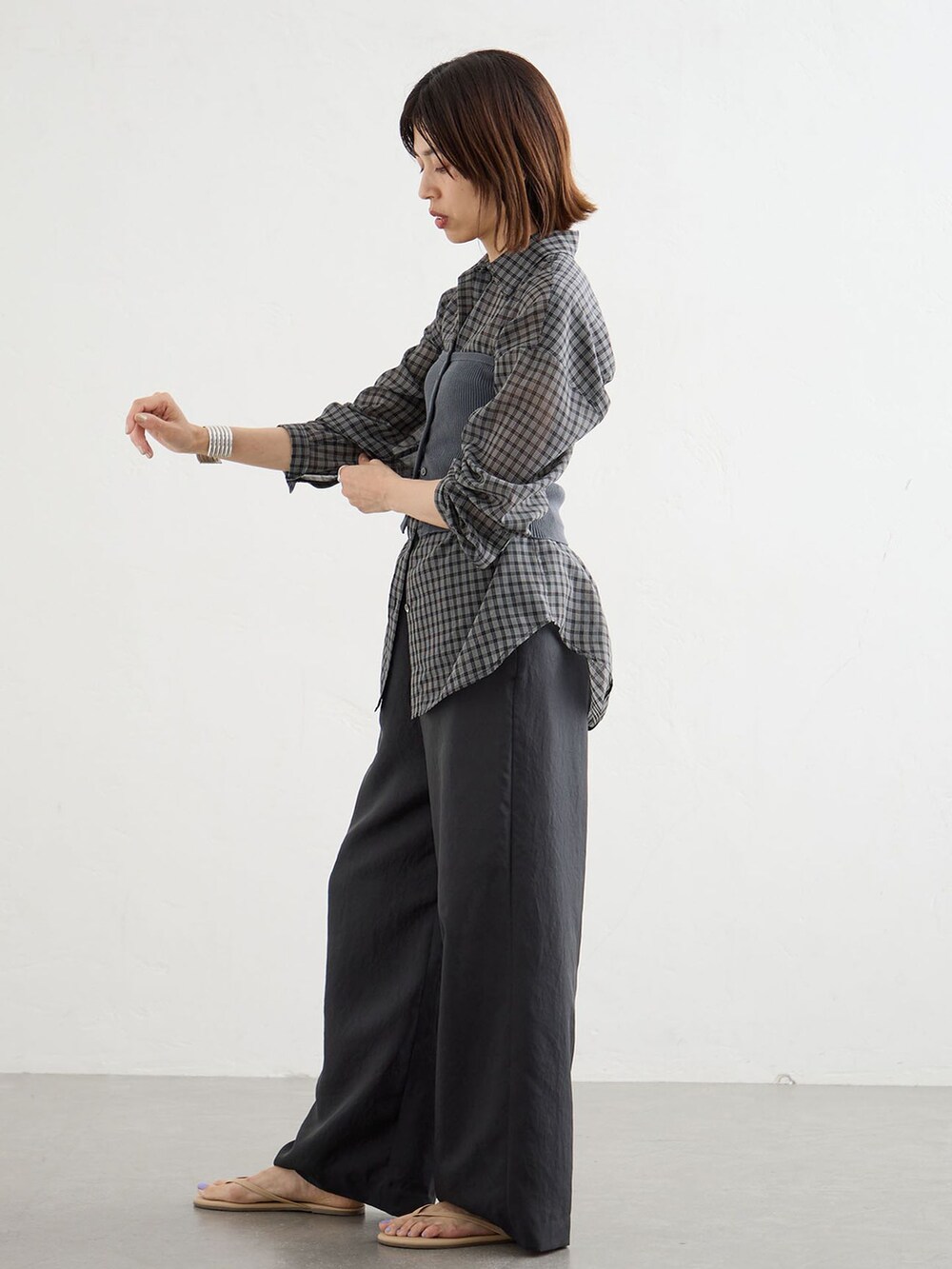 ブラック系のその他パンツ、ブラック系のシャツ/ブラウス、グレー系のニット/セーターを着用したレディースの夏コーディネートの2枚目の写真