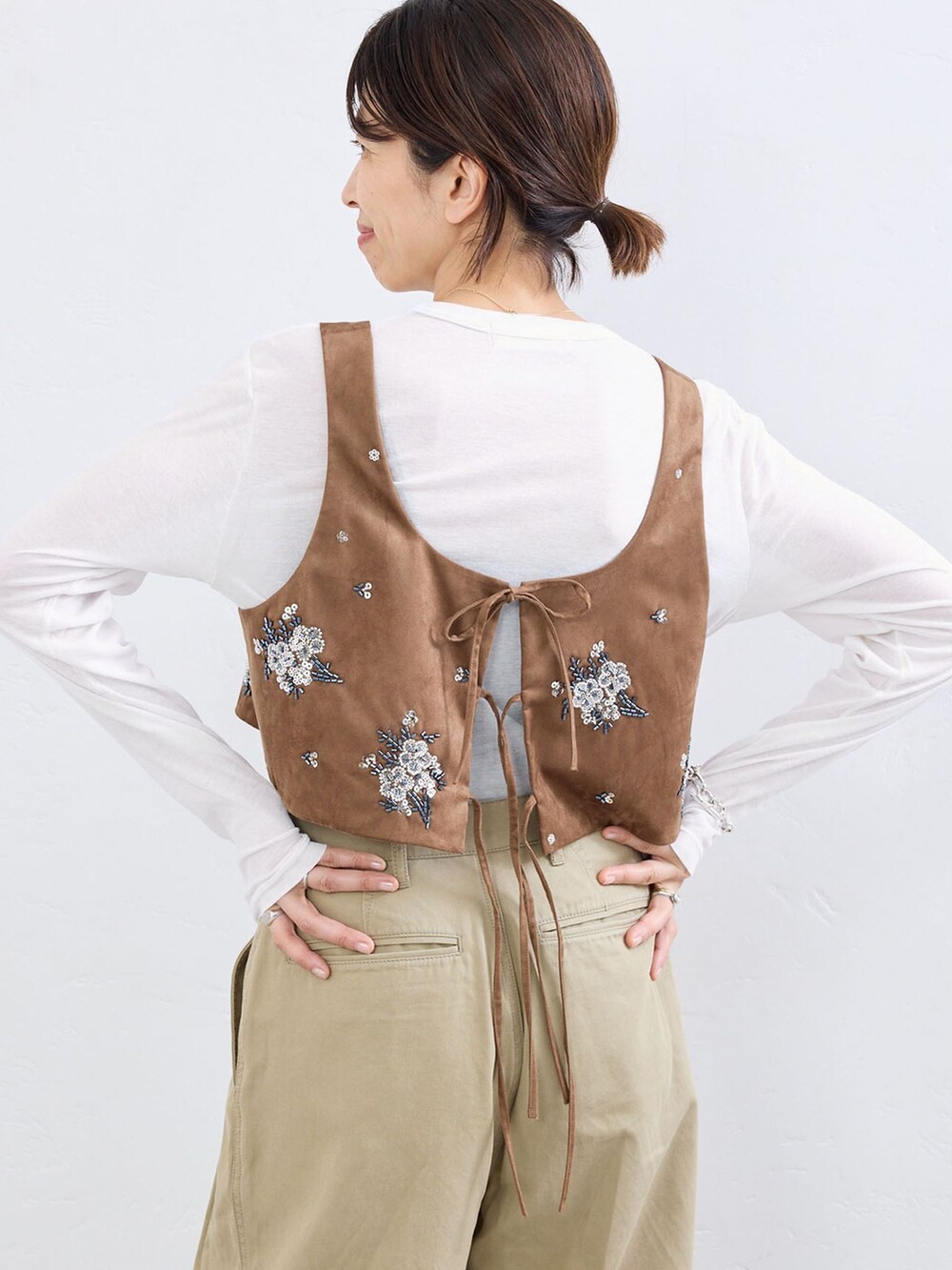 ベージュ系のチノパンツ、イエロー系のシャツ/ブラウス、ホワイト系のTシャツ/カットソーを着用したレディースの夏コーディネートの4枚目の写真