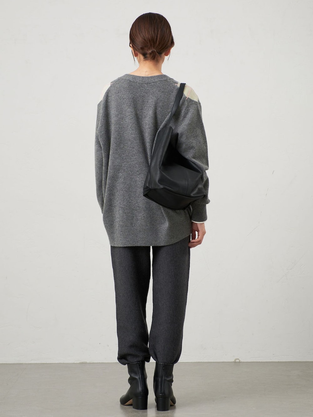 グレー系のその他パンツ、グレー系のカーディガン/ボレロ、ブラック系のブーツを着用したレディースの秋コーディネートの3枚目の写真