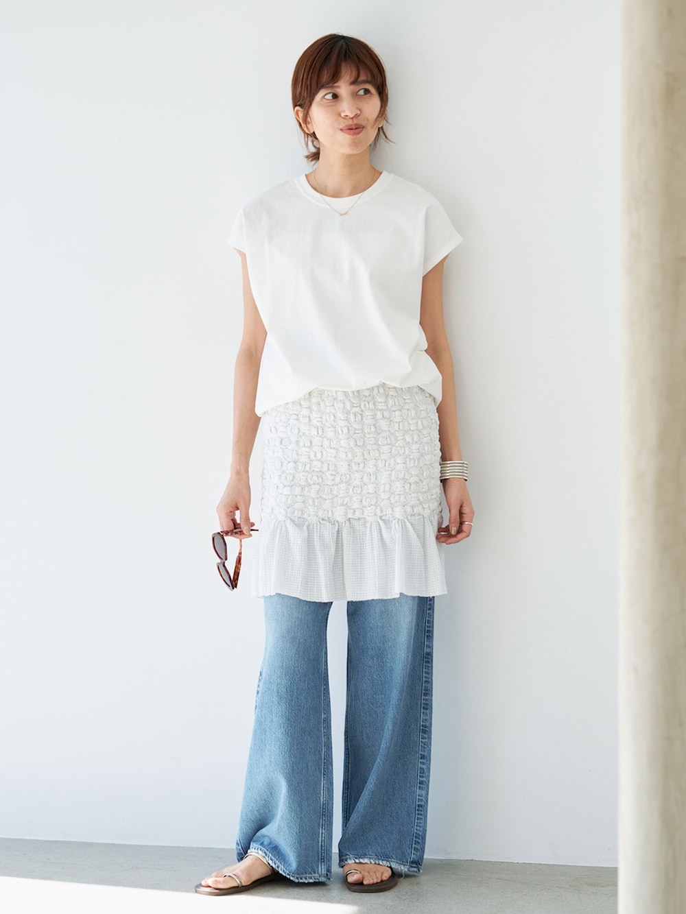 ホワイト系のスカート、ホワイト系のTシャツ/カットソー、ブラウン系のサンダルを着用したレディースの春コーディネートの3枚目の写真