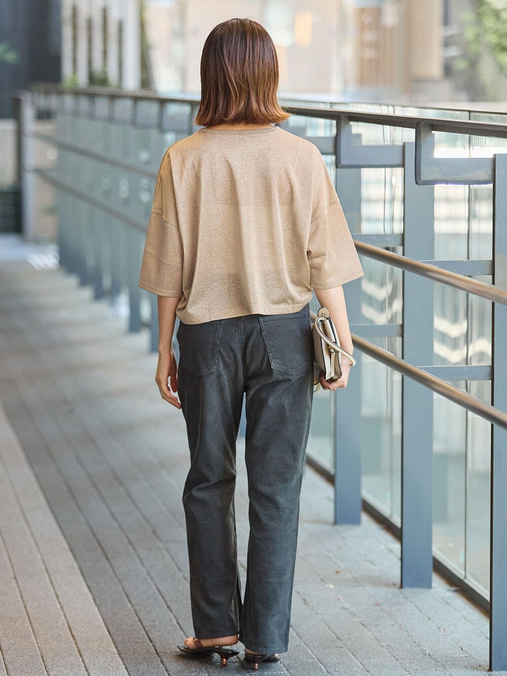 ブラック系のその他パンツ、ゴールド系のTシャツ/カットソー、ブラウン系のサンダルを着用したレディースの夏コーディネートの3枚目の写真