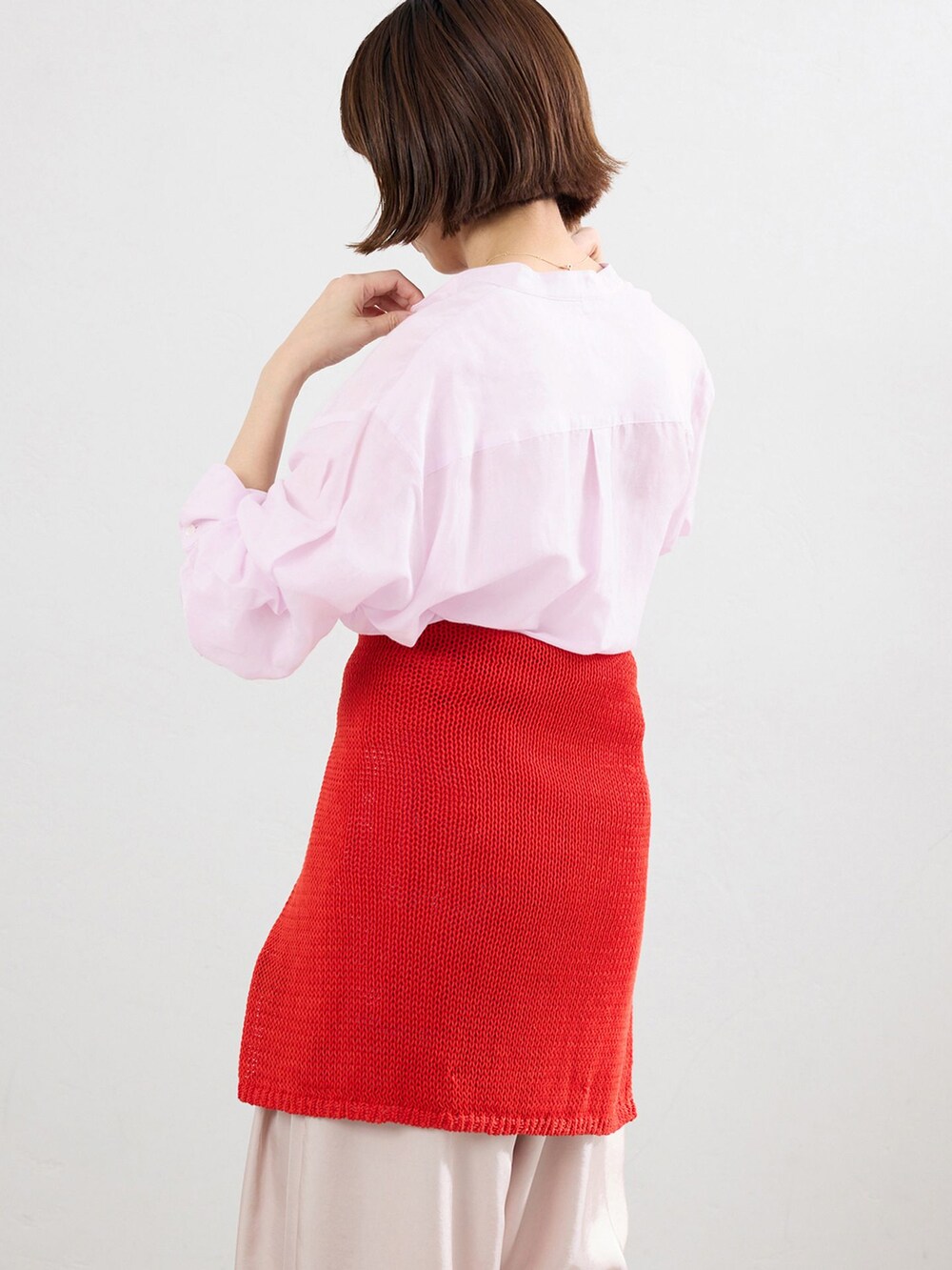 ピンク系のシャツ/ブラウス、レッド系のニット/セーター、レッド系のパンプスを着用したレディースの春コーディネートの4枚目の写真