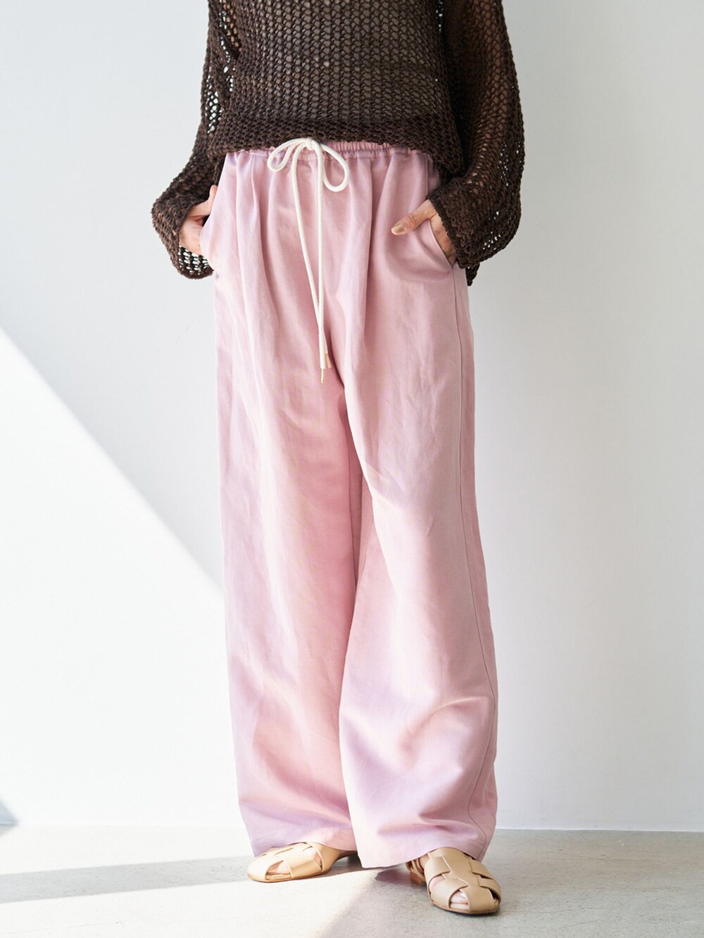ピンク系のその他パンツ、ブラウン系のニット/セーター、ベージュ系のサンダルを着用したレディースの春コーディネートの8枚目の写真