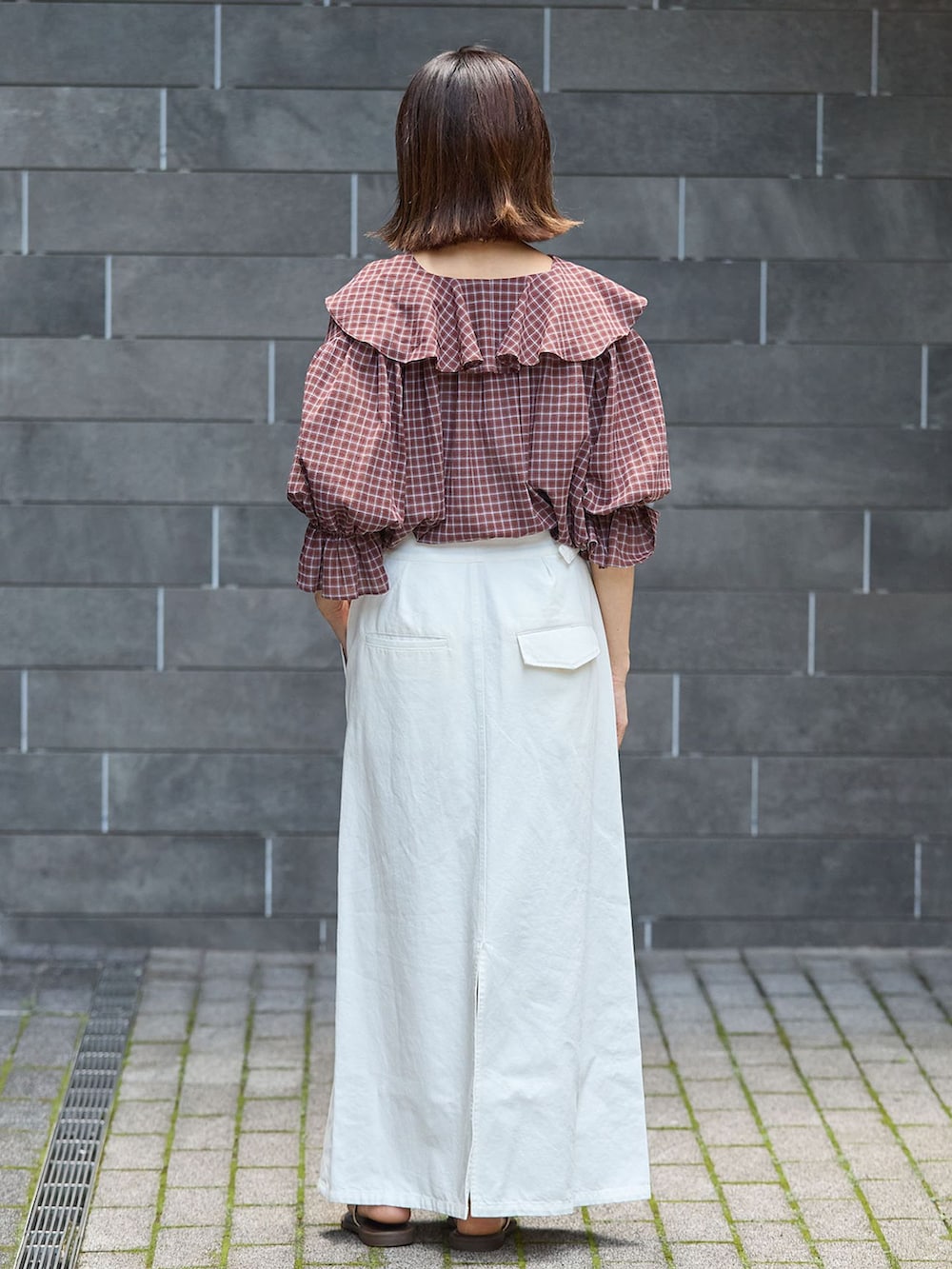 レッド系のシャツ/ブラウス、ホワイト系のスカート、ブラウン系のサンダルを着用したレディースの夏コーディネートの3枚目の写真