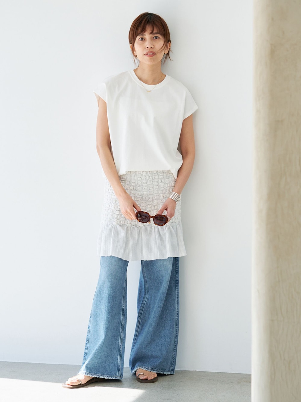 ホワイト系のスカート、ホワイト系のTシャツ/カットソー、ブラウン系のサンダルを着用したレディースの春コーディネートの2枚目の写真