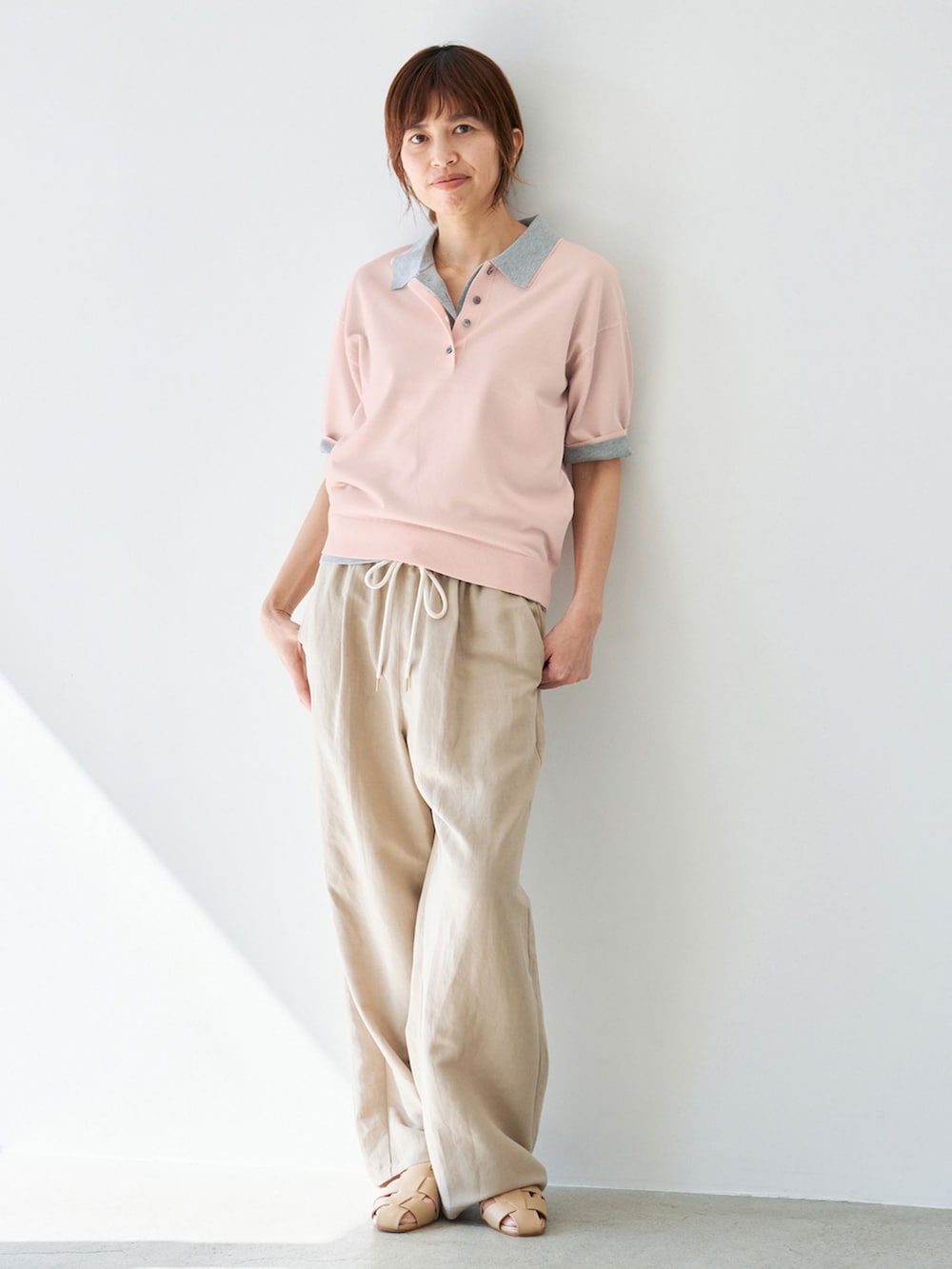 ベージュ系のその他パンツ、グレー系のニット/セーター、ピンク系のニット/セーターを着用したレディースの春コーディネートの2枚目の写真