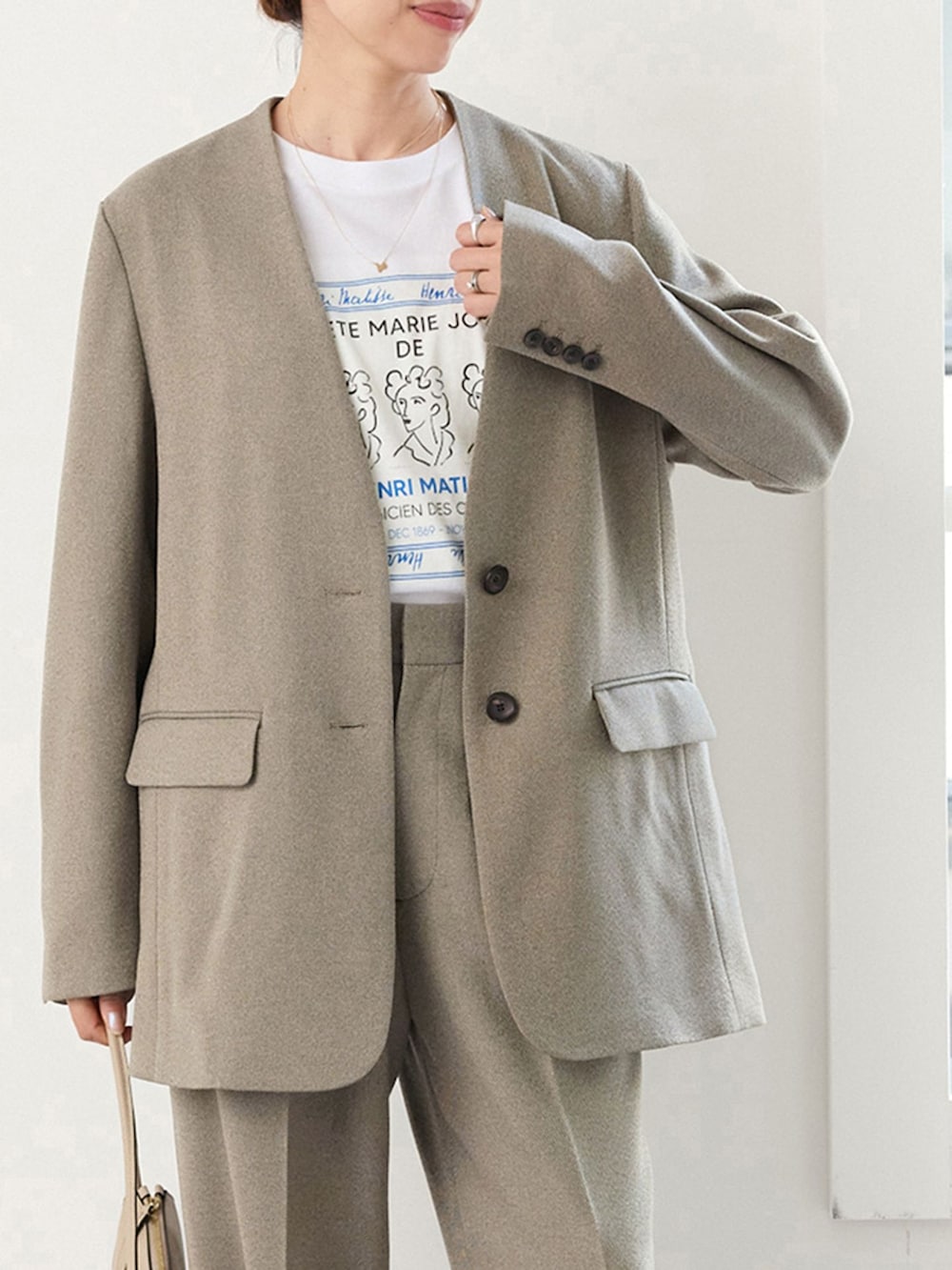 ベージュ系のスラックス、ホワイト系のTシャツ/カットソーを着用したレディースの夏コーディネートの4枚目の写真