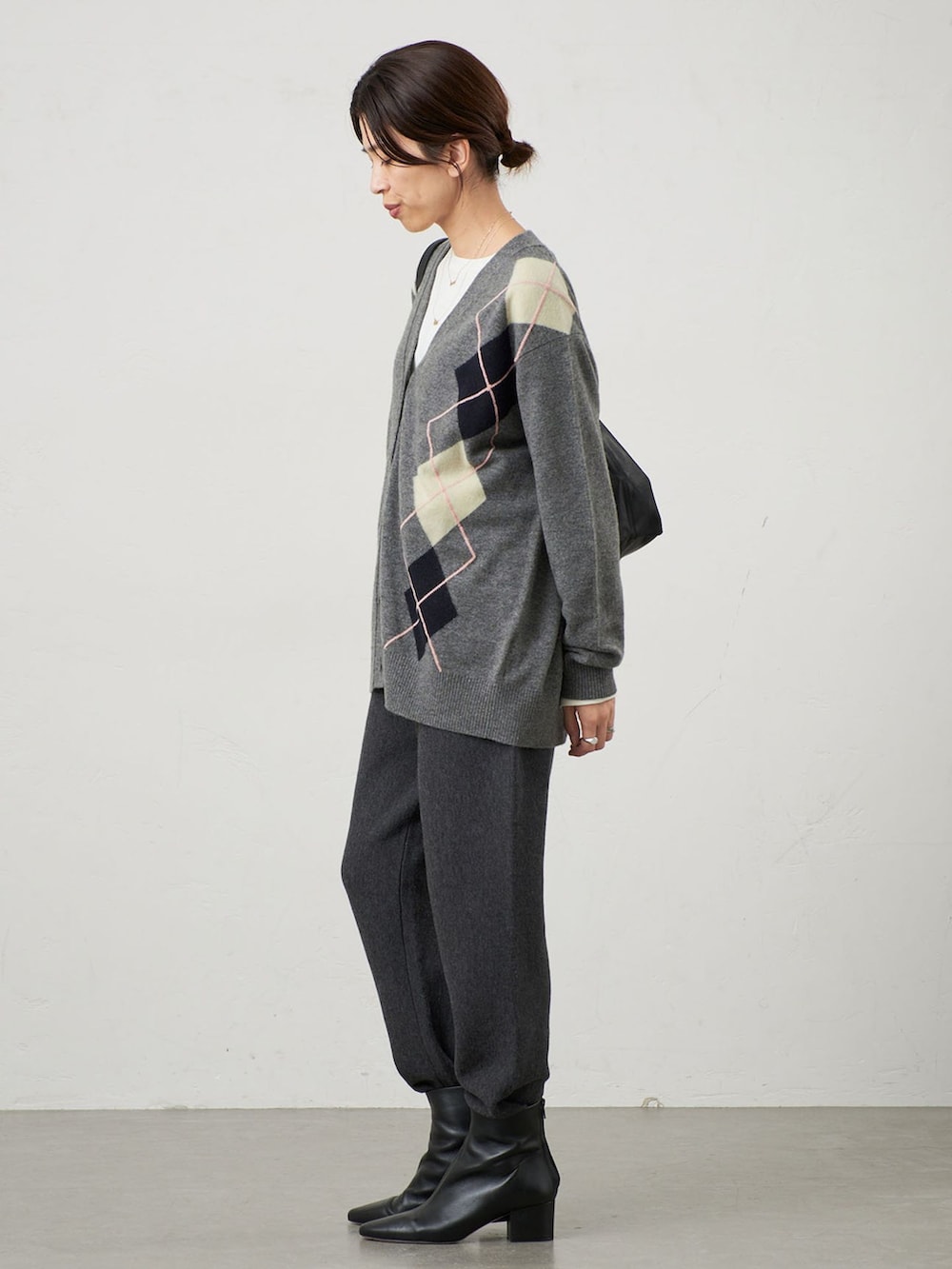 グレー系のその他パンツ、グレー系のカーディガン/ボレロ、ブラック系のブーツを着用したレディースの秋コーディネートの2枚目の写真