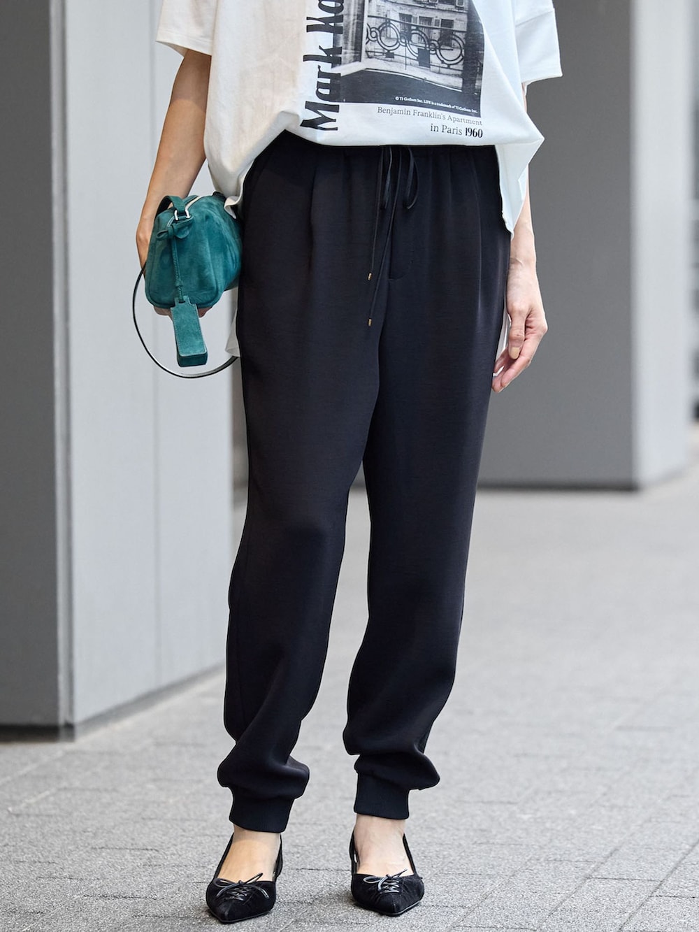 ブラック系のスウェットパンツ、ホワイト系のTシャツ/カットソーを着用したレディースの夏コーディネートの4枚目の写真