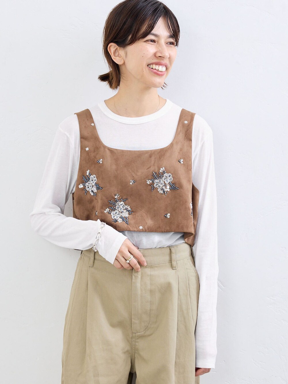 ベージュ系のチノパンツ、イエロー系のシャツ/ブラウス、ホワイト系のTシャツ/カットソーを着用したレディースの夏コーディネートの3枚目の写真