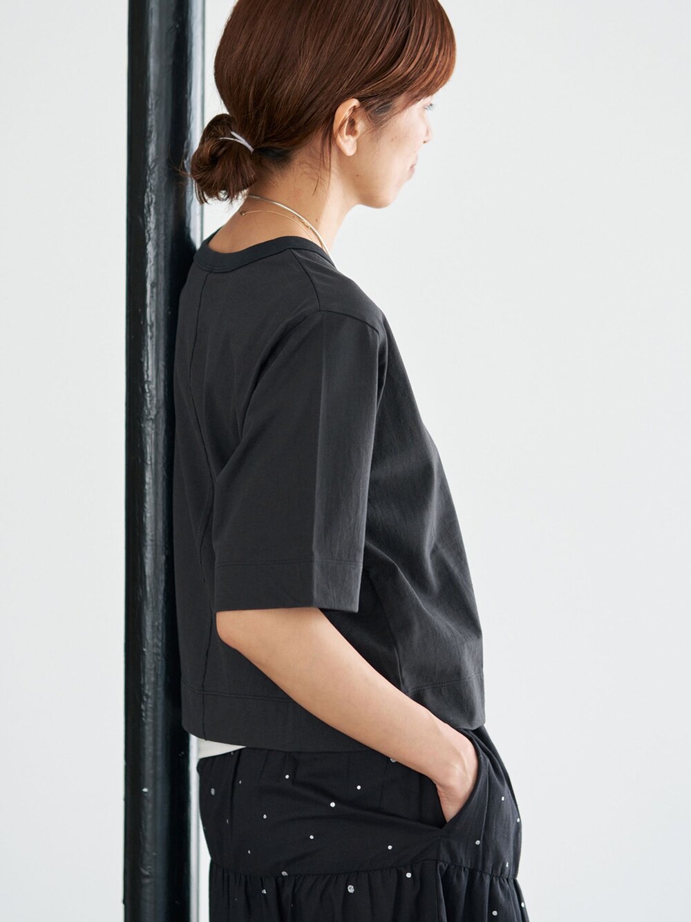 ブラック系のスカート、ブラック系のTシャツ/カットソーを着用したレディースの夏コーディネートの7枚目の写真