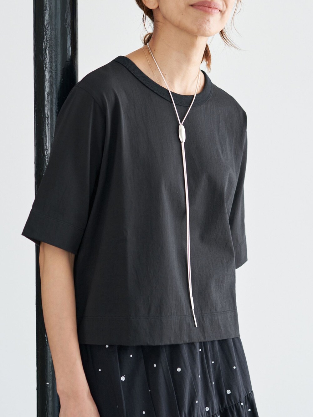 ブラック系のスカート、ブラック系のTシャツ/カットソーを着用したレディースの夏コーディネートの8枚目の写真
