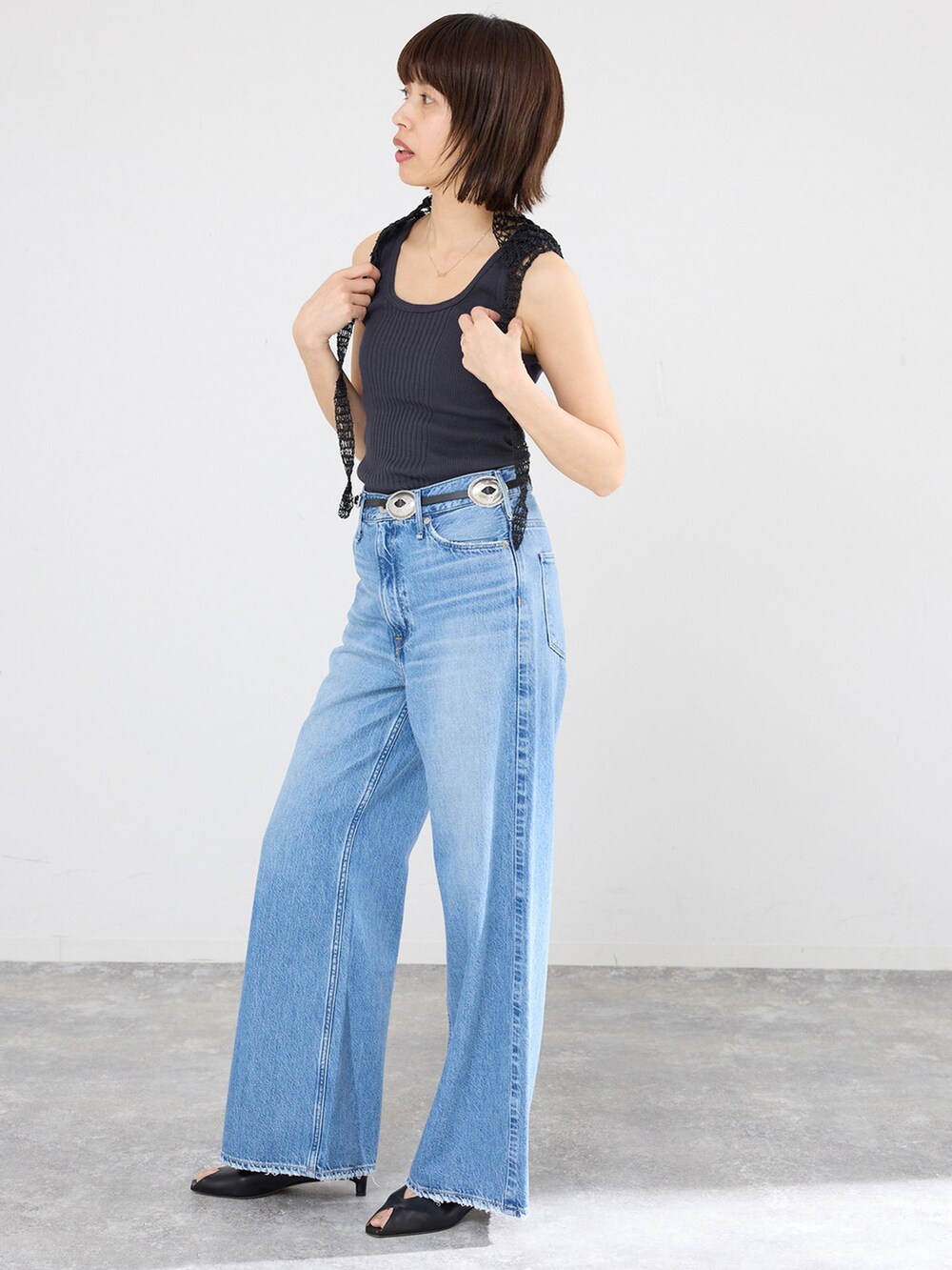 ブルー系のデニムパンツ、ブラック系のタンクトップを着用したレディースの春コーディネートの2枚目の写真