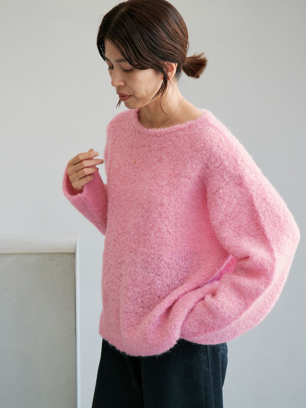 ブラック系のデニムパンツ、ピンク系のニット/セーターを着用したレディースの夏コーディネートの4枚目の写真