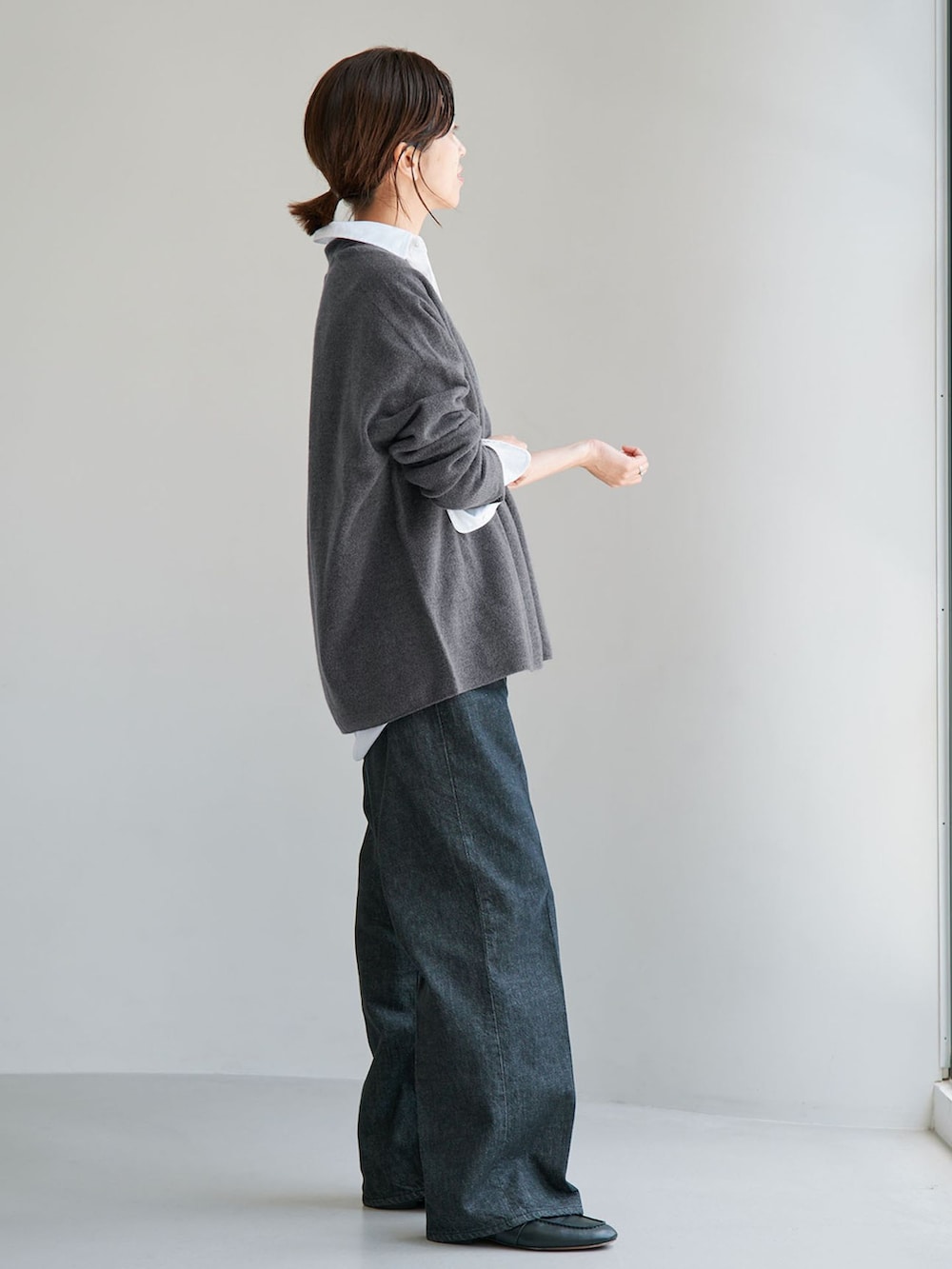 ブルー系のデニムパンツ、グレー系のニット/セーター、ブラック系のローファーを着用したレディースの夏コーディネートの2枚目の写真