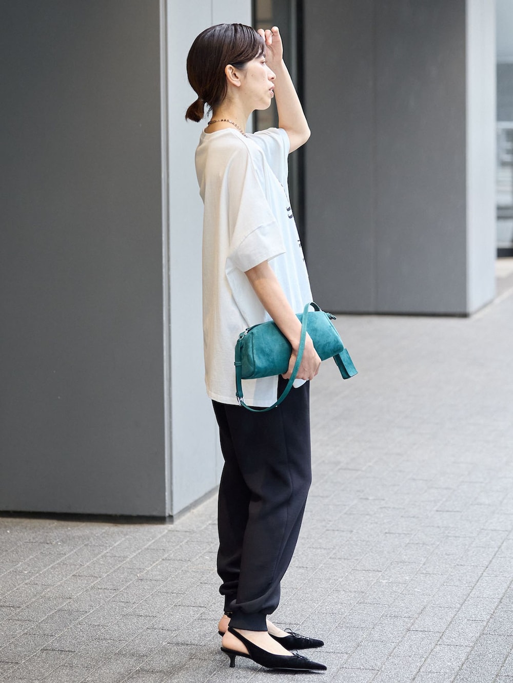 ブラック系のスウェットパンツ、ホワイト系のTシャツ/カットソーを着用したレディースの夏コーディネートの2枚目の写真