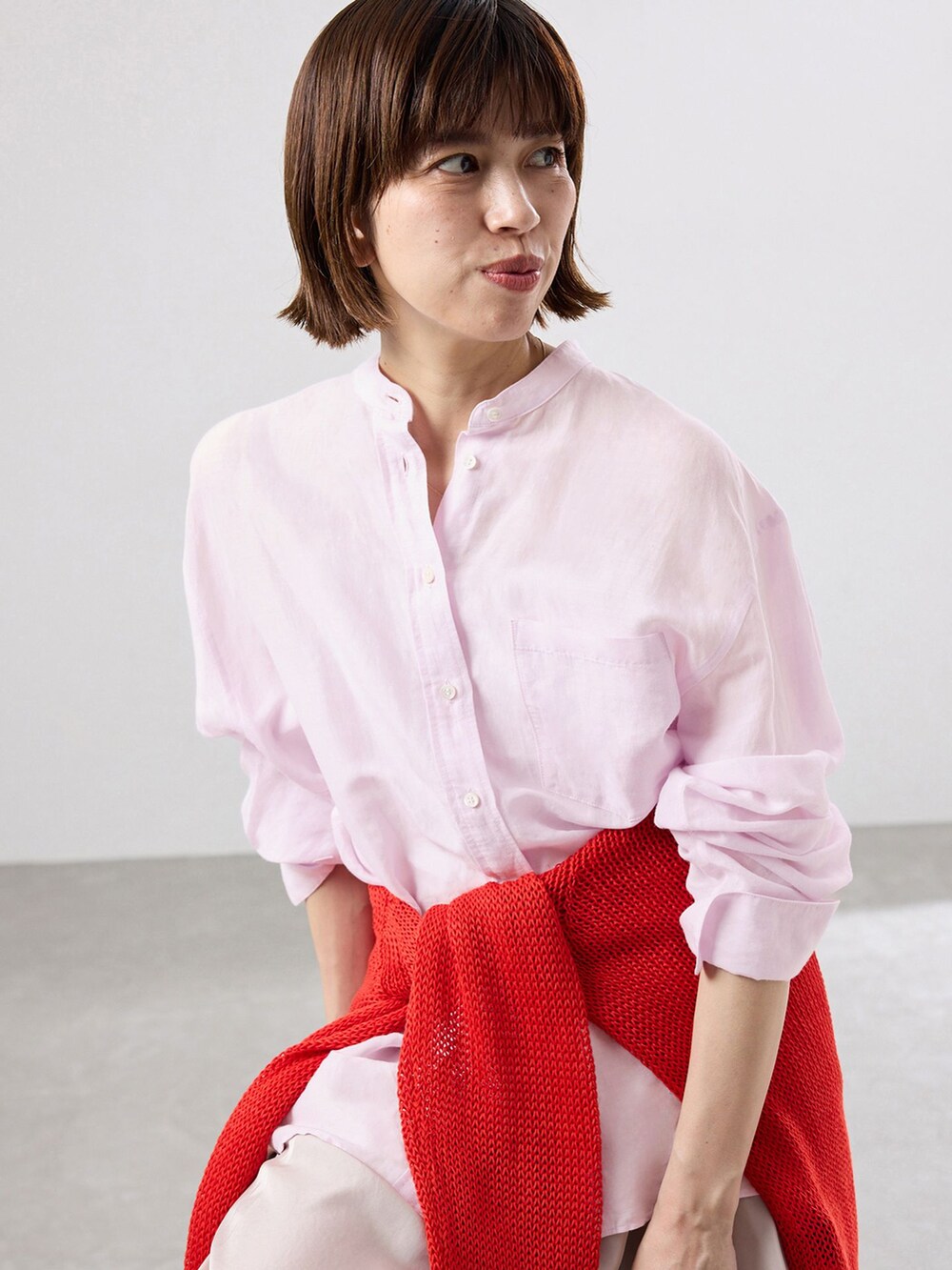 ピンク系のシャツ/ブラウス、レッド系のニット/セーター、レッド系のパンプスを着用したレディースの春コーディネートの3枚目の写真