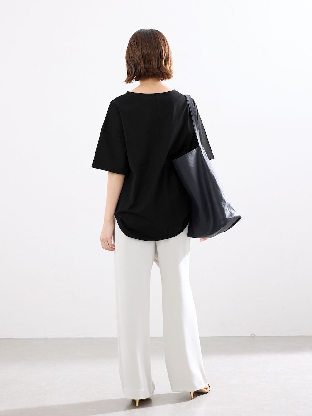 ベージュ系のその他パンツ、ブラック系のTシャツ/カットソー、ブラック系のショルダーバッグを着用したレディースの春コーディネートの3枚目の写真
