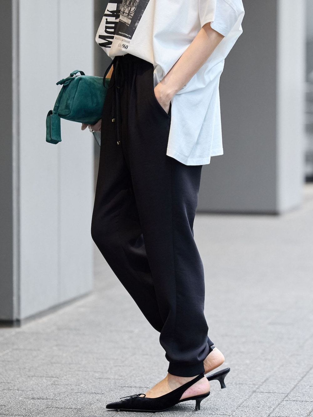 ブラック系のスウェットパンツ、ホワイト系のTシャツ/カットソーを着用したレディースの夏コーディネートの5枚目の写真