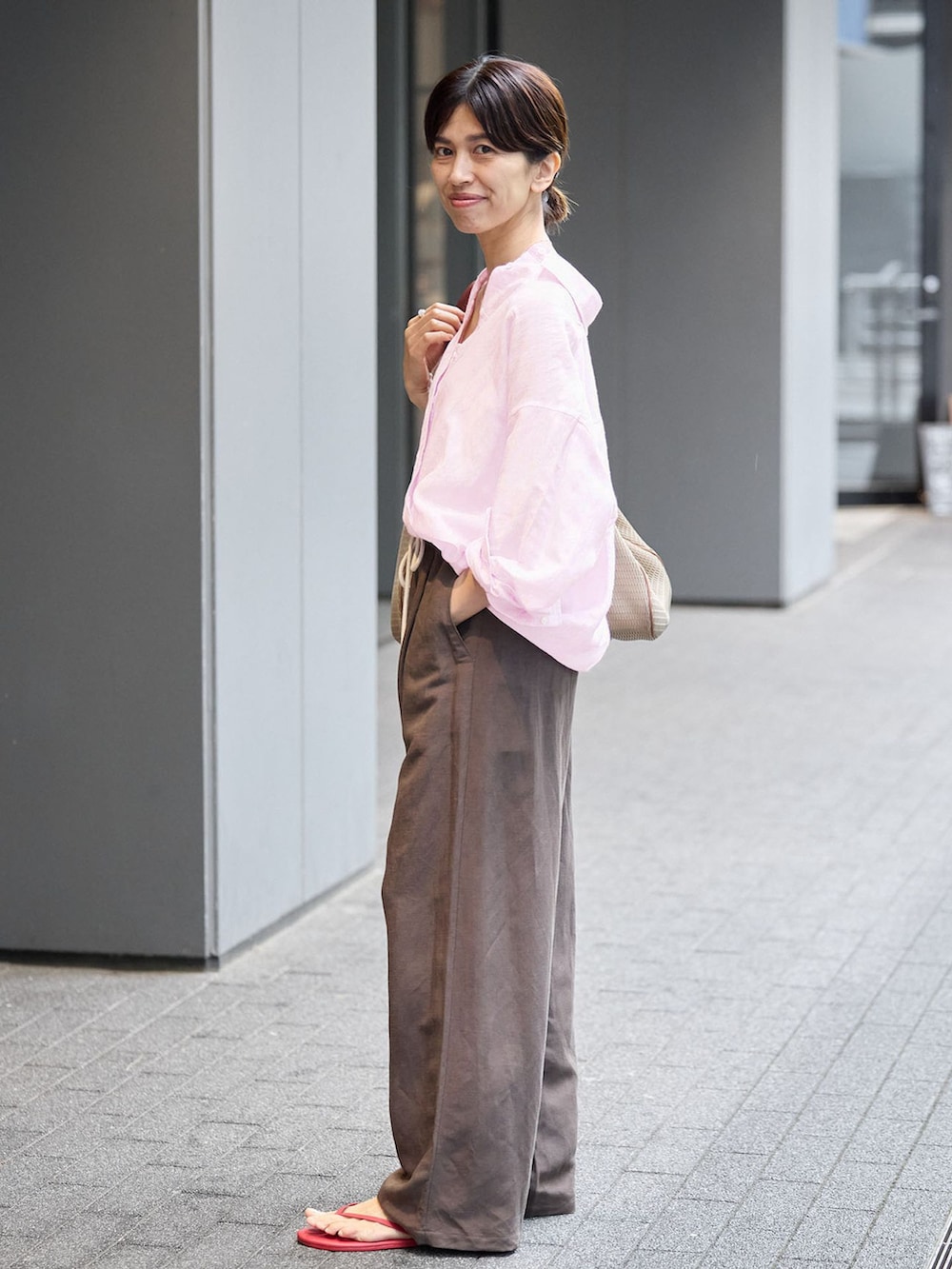 ブラウン系のその他パンツ、ピンク系のシャツ/ブラウス、レッド系のサンダルを着用したレディースの夏コーディネートの2枚目の写真