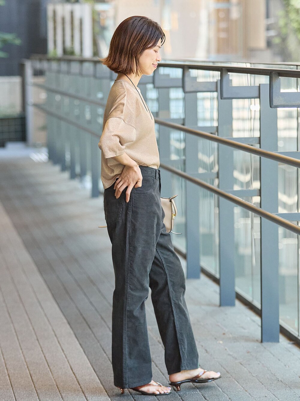 ブラック系のその他パンツ、ゴールド系のTシャツ/カットソー、ブラウン系のサンダルを着用したレディースの夏コーディネートの2枚目の写真