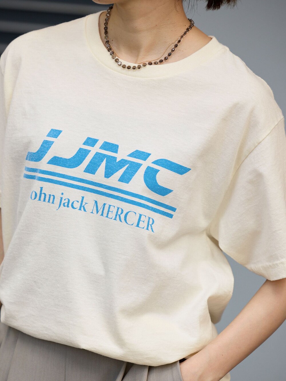 ベージュ系のスラックス、ホワイト系のTシャツ/カットソー、ブラウン系のバックパック/リュックを着用したレディースの夏コーディネートの5枚目の写真