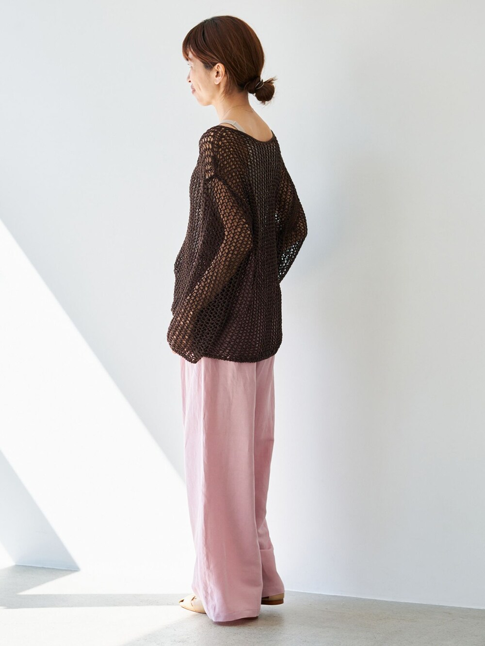 ピンク系のその他パンツ、ブラウン系のニット/セーター、ベージュ系のサンダルを着用したレディースの春コーディネートの3枚目の写真