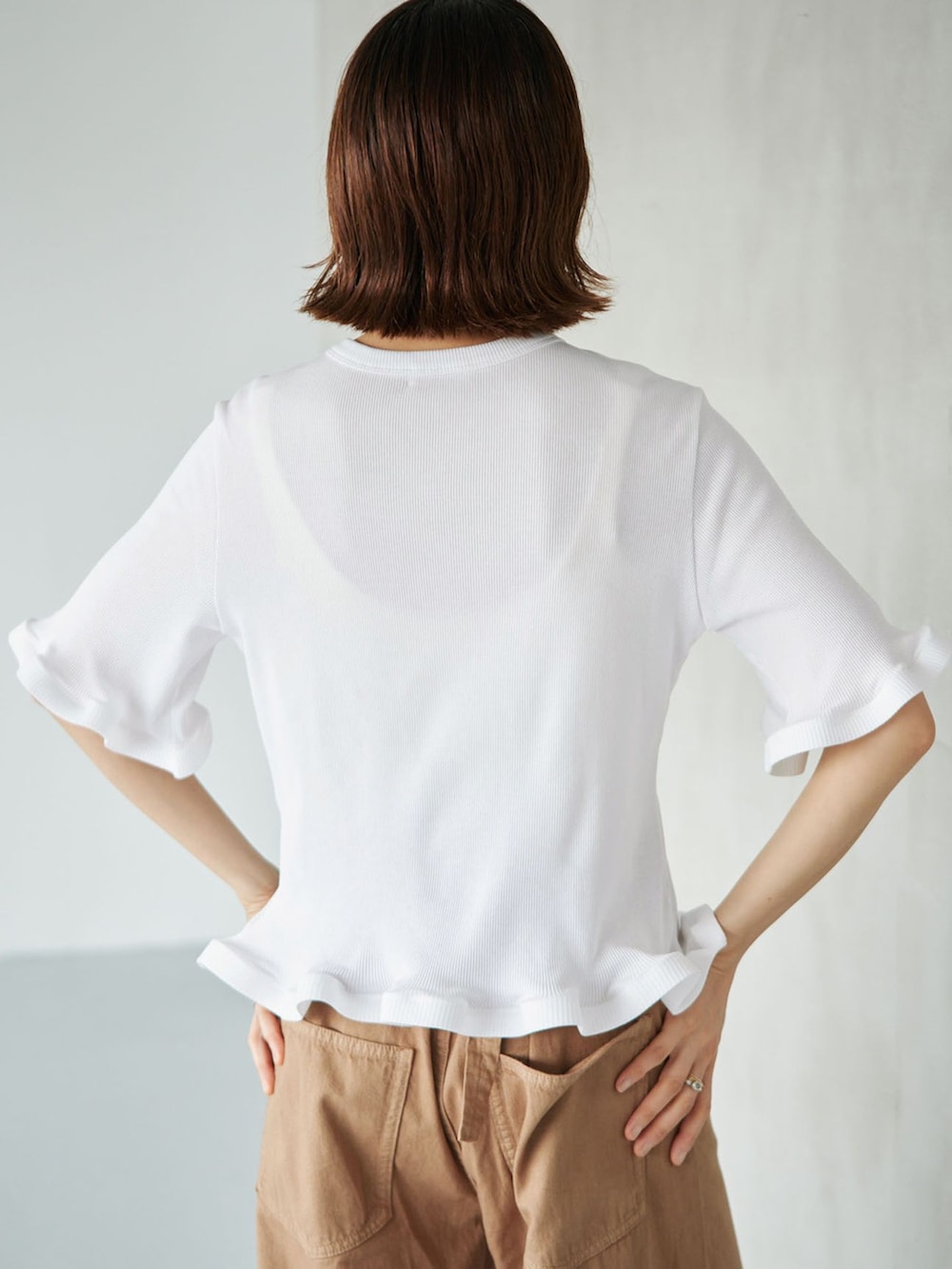 イエロー系のチノパンツ、ホワイト系のTシャツ/カットソー、ブラウン系のサンダルを着用したレディースの夏コーディネートの5枚目の写真