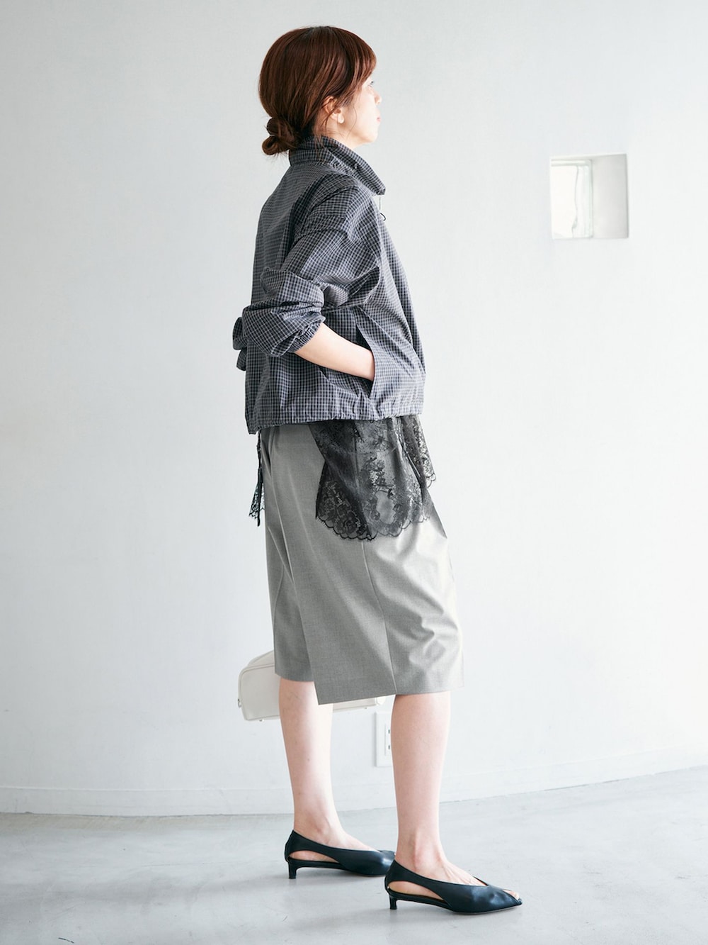 グレー系のその他パンツ、ホワイト系のショルダーバッグを着用したレディースの冬コーディネートの2枚目の写真