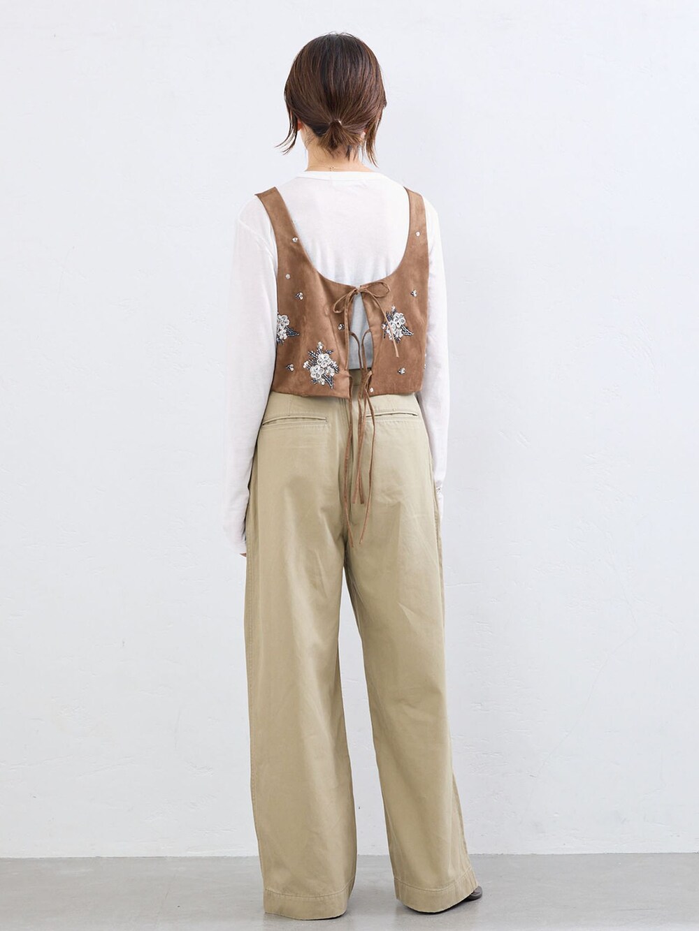 ベージュ系のチノパンツ、イエロー系のシャツ/ブラウス、ホワイト系のTシャツ/カットソーを着用したレディースの夏コーディネートの2枚目の写真