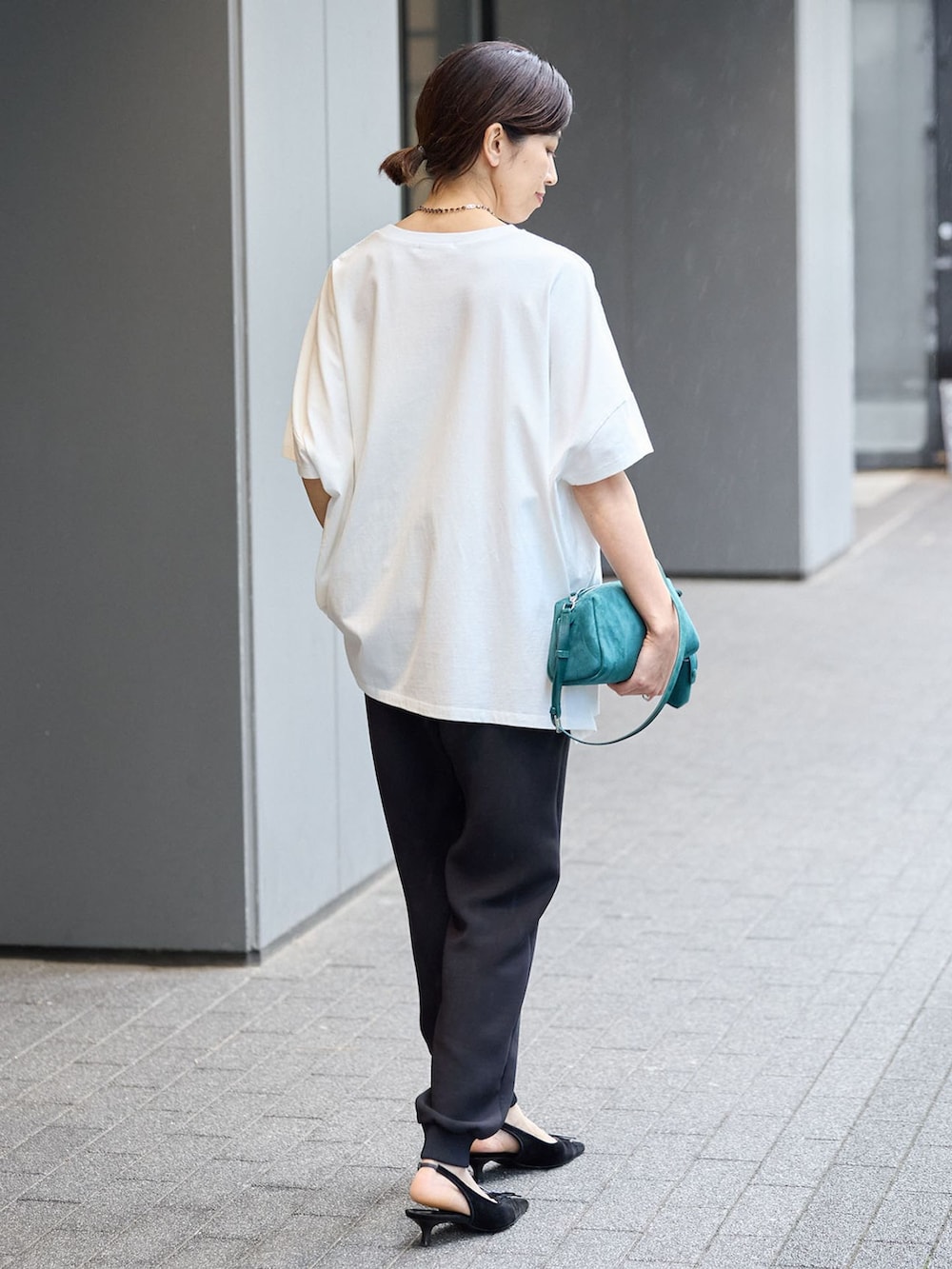ブラック系のスウェットパンツ、ホワイト系のTシャツ/カットソーを着用したレディースの夏コーディネートの3枚目の写真