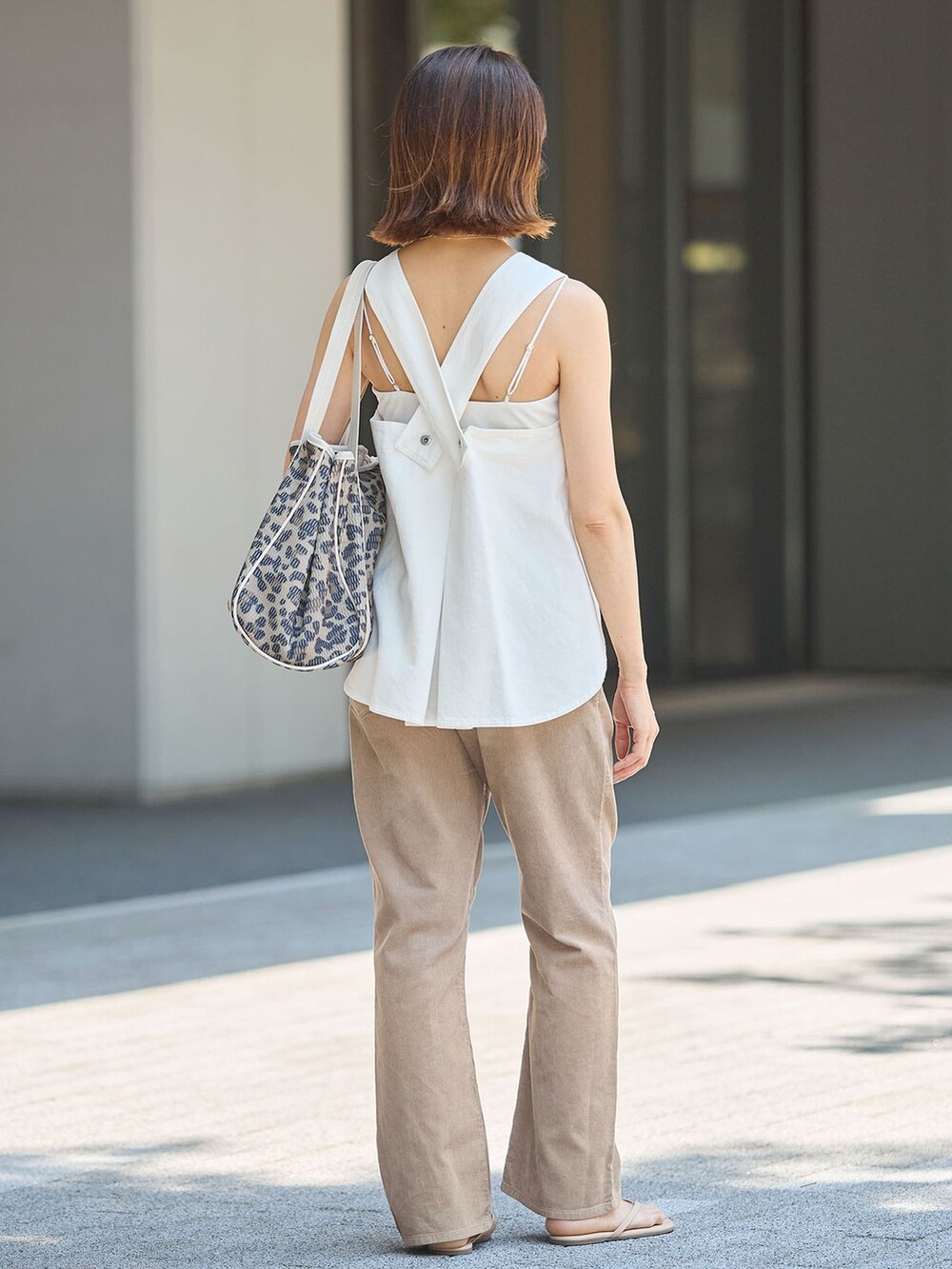 ベージュ系のその他パンツ、ブラウン系のトートバッグ、ベージュ系のサンダルを着用したレディースの夏コーディネートの2枚目の写真