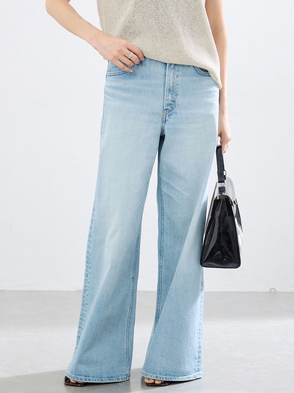 ブルー系のデニムパンツ、ベージュ系のニット/セーターを着用したレディースの春コーディネートの3枚目の写真