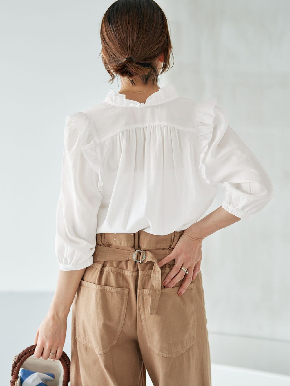イエロー系のチノパンツ、ホワイト系のシャツ/ブラウス、イエロー系のハンドバッグを着用したレディースの夏コーディネートの4枚目の写真