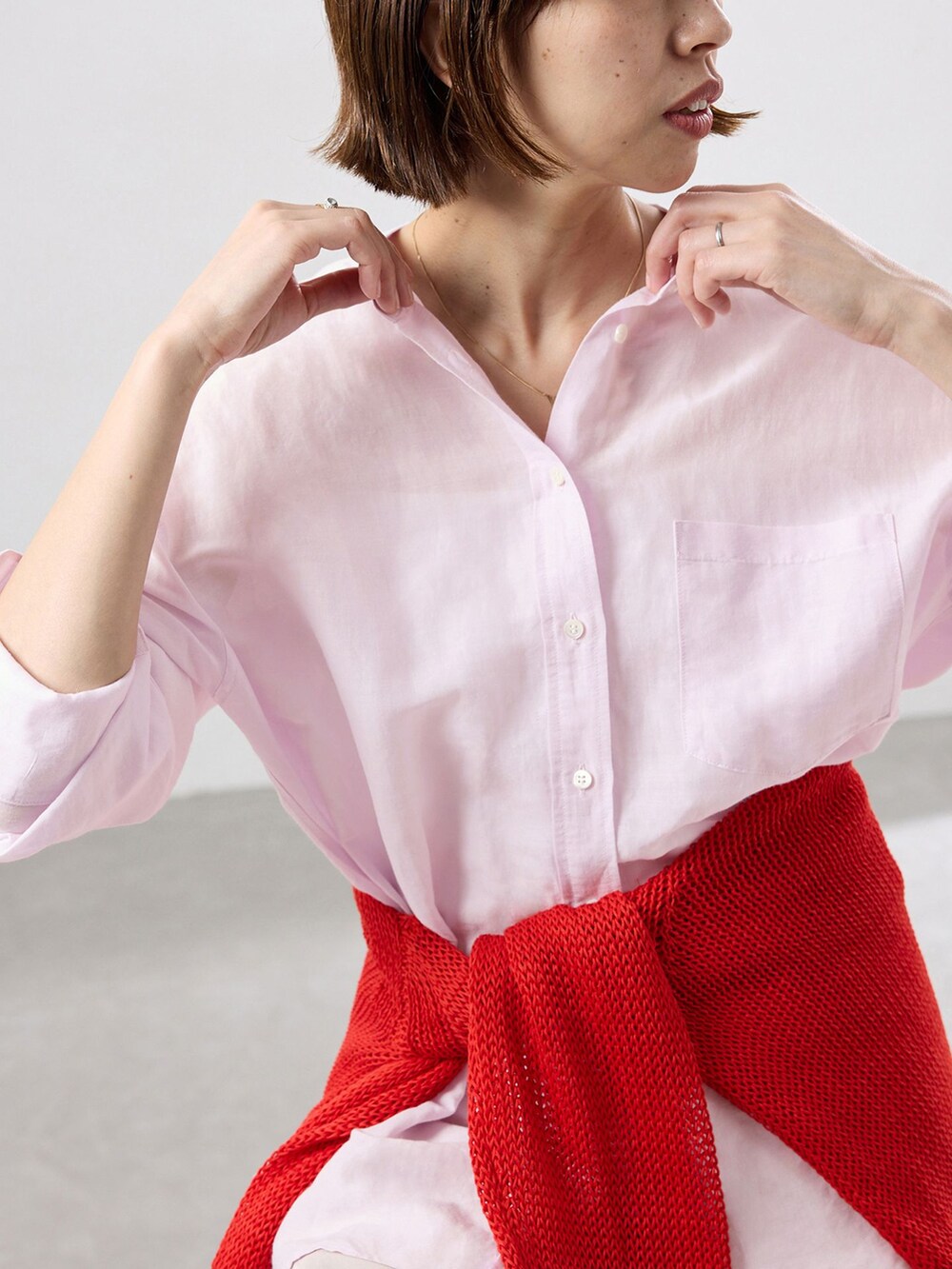 ピンク系のシャツ/ブラウス、レッド系のニット/セーター、レッド系のパンプスを着用したレディースの春コーディネートの5枚目の写真
